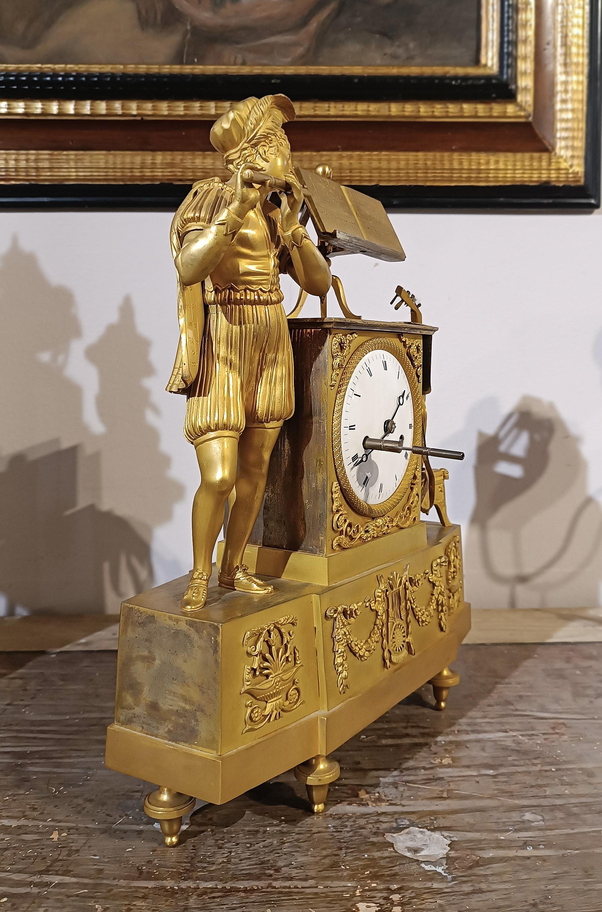 Refined gilded bronze clock with splendid gilding. The piece features classical decorations, typical of the period, with festoons and musical instruments. At the top, a guitar rests on a musician's stool to the right, while to the left is a young