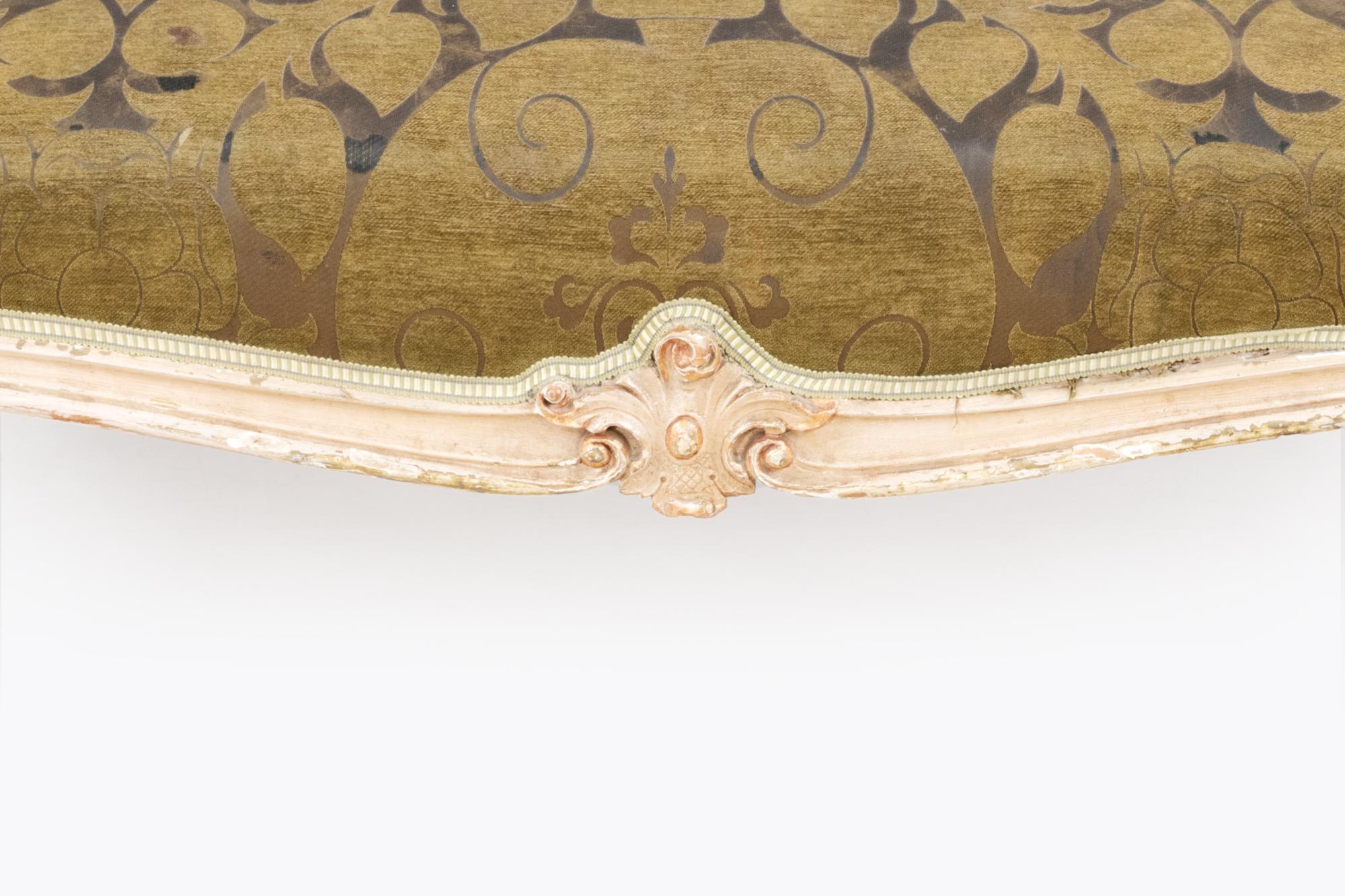 Late 18th century giltwood central ottoman. The upholstered cushion top sits above a gilt frame elegantly carved with central cartouches and cabriole legs terminating in scrolled feet.