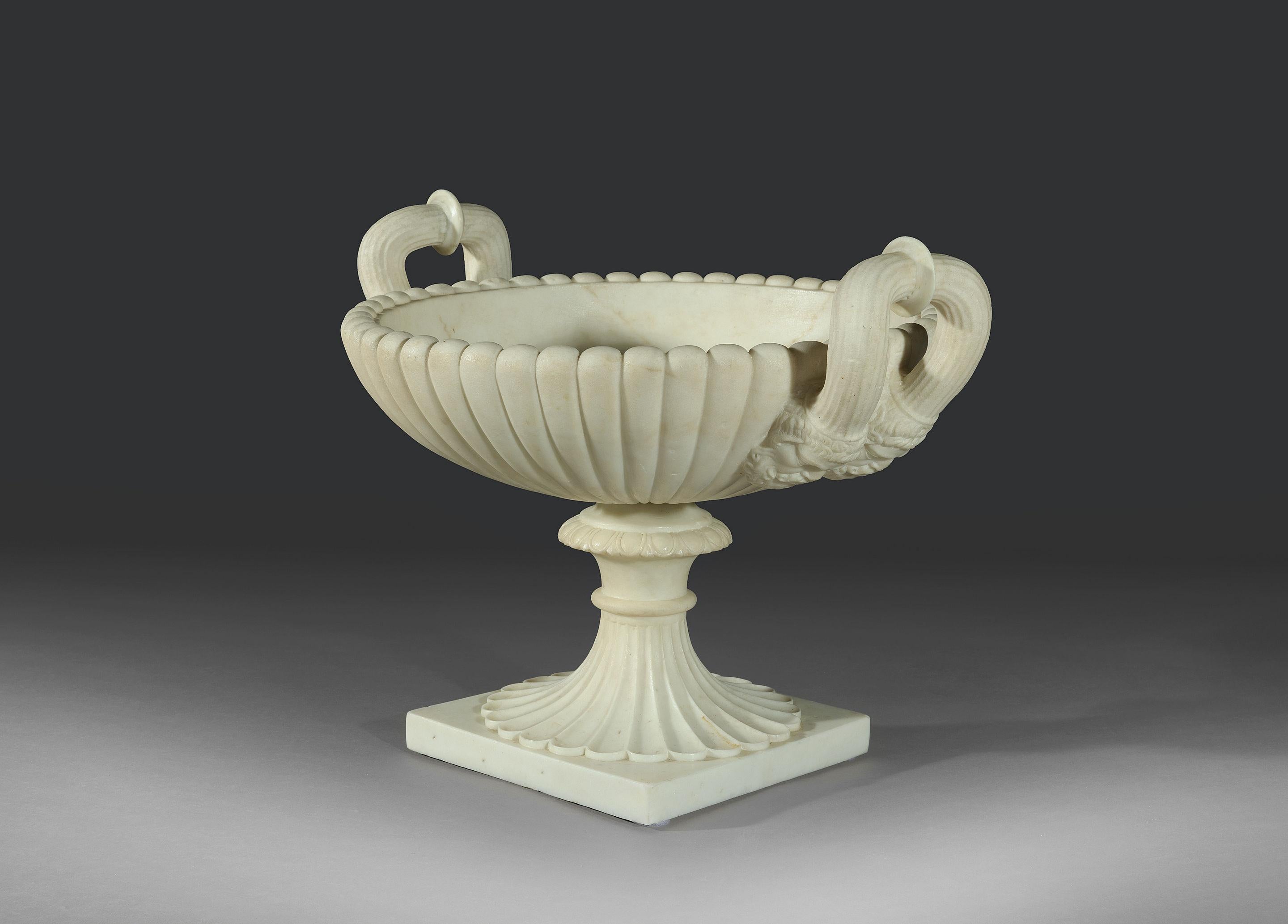 The large gadrooned bowl is adorned with generously proportioned fluted handles, that emerge from the heads of two beautifully detailed Seilenoi, the whole being carved from one piece. The bowl is fitted with brass pin that rests on a solid carved