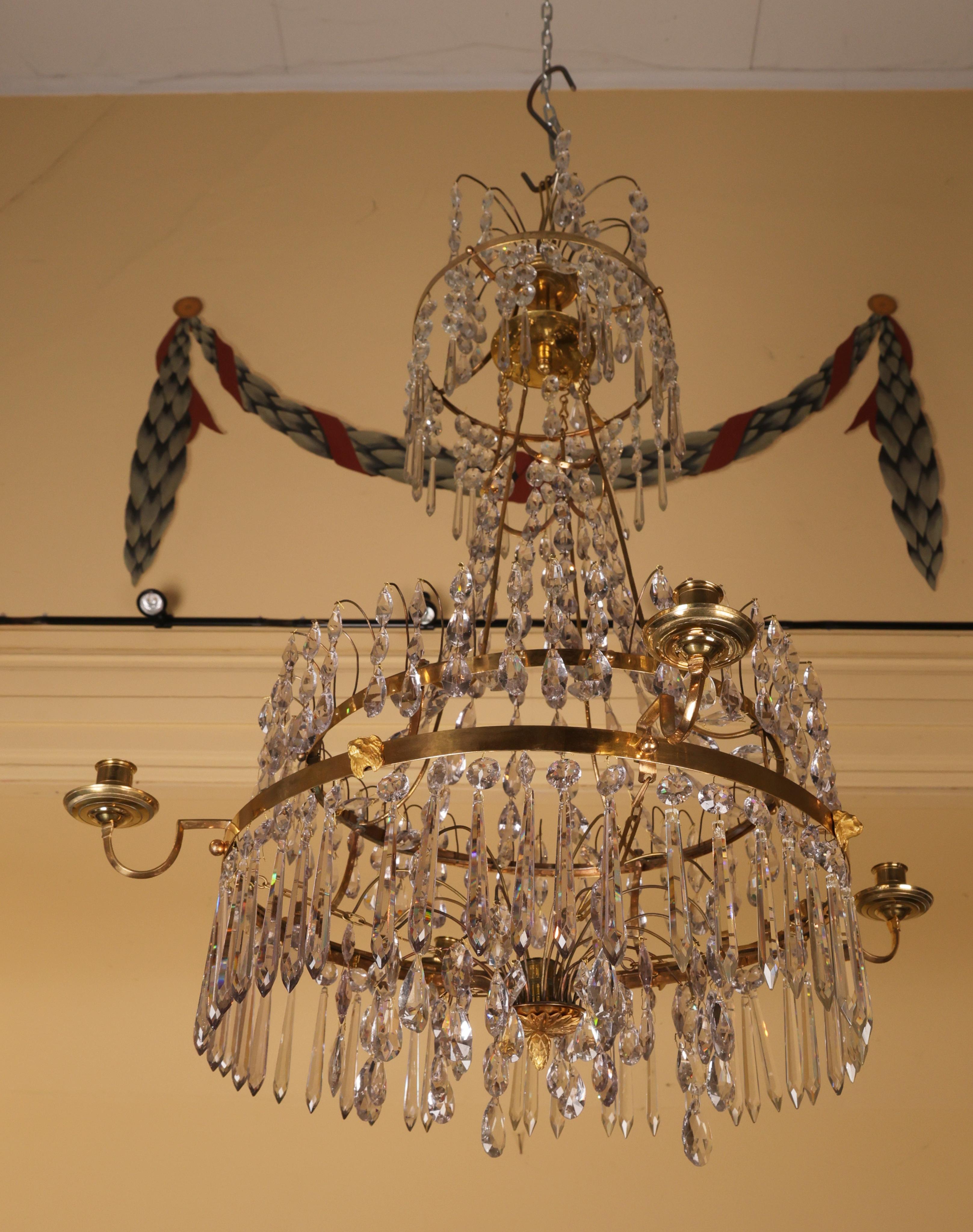 Lustre de style gustavien tardif fabriqué à Stockholm à la fin du XVIIIe siècle. Le lustre est doté de quatre bras pour les bougies et d'un cadre en bronze doré au feu. Son élégance est renforcée par l'absence de trous percés dans les anneaux ; à la
