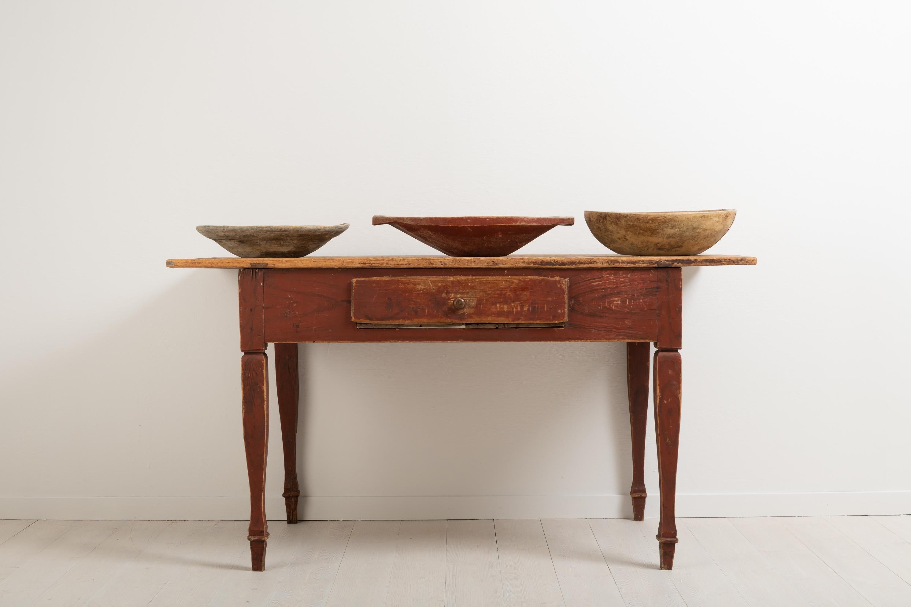 Gustavian styled work table from the county Norrbotten in northern Sweden. The table was manufactured during the late 18th century and has a faux painted leg frame. The wooden knob on the drawer is original. An unusual detail is that the long sides