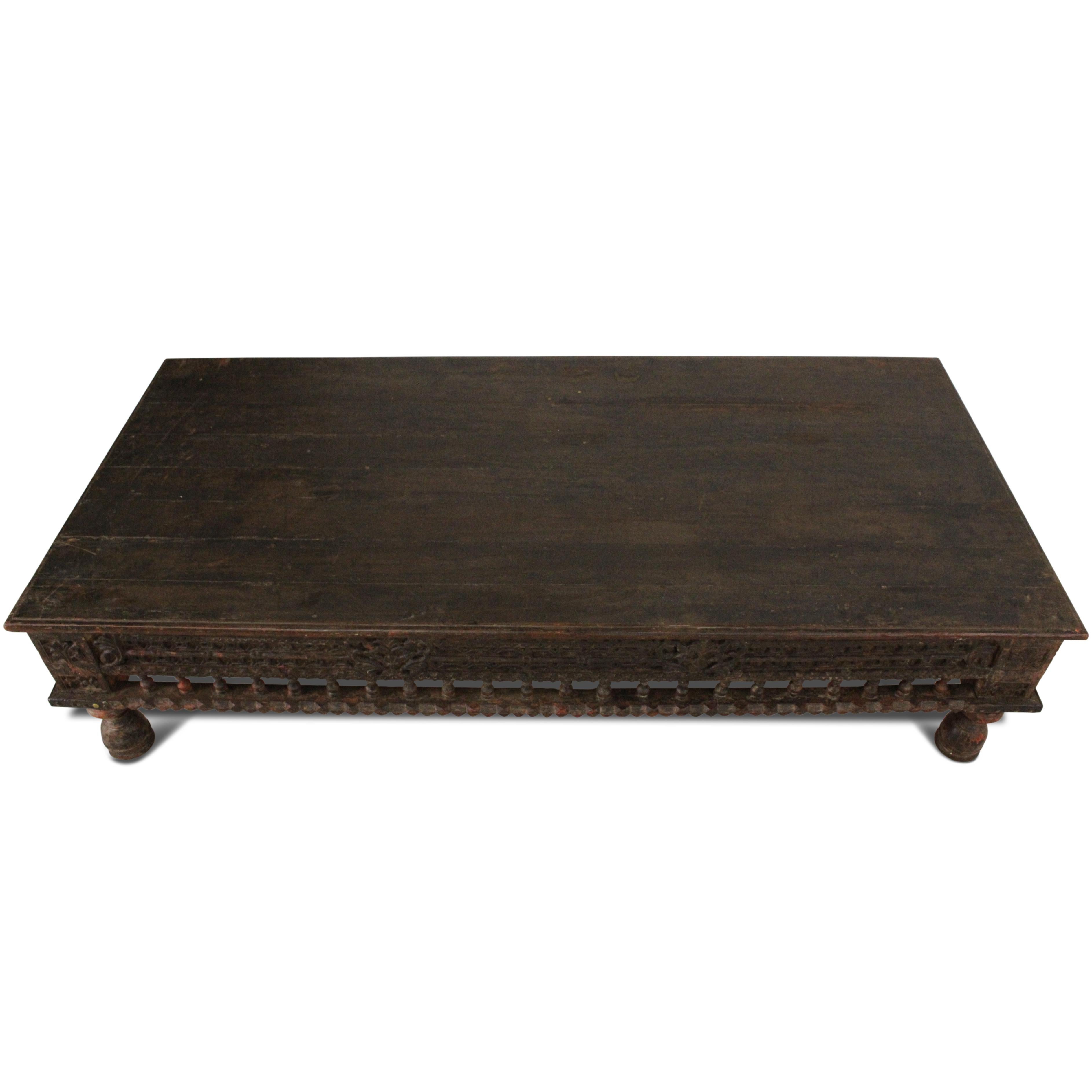 A late 18th-century teak daybed or coffee table of exceptional quality, with a solid wood top and exquisite carved details on the apron. It retains traces of its original vegetable dye paint in certain areas and the history of the piece shows on a