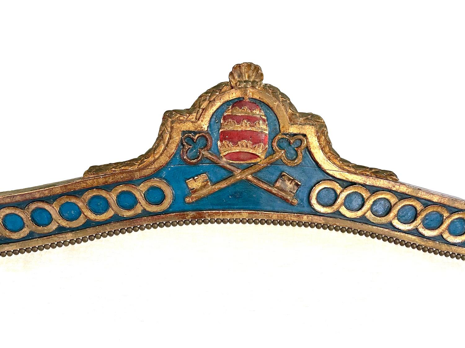 An extremely rare neoclassical parcel-gilt and painted banquette in the transitional Louis XV/XVI style, likely from Marche, Italy, circa 1790, carved on the back rail with the Papal crest depicting crossed keys beneath three gold crowns on a red