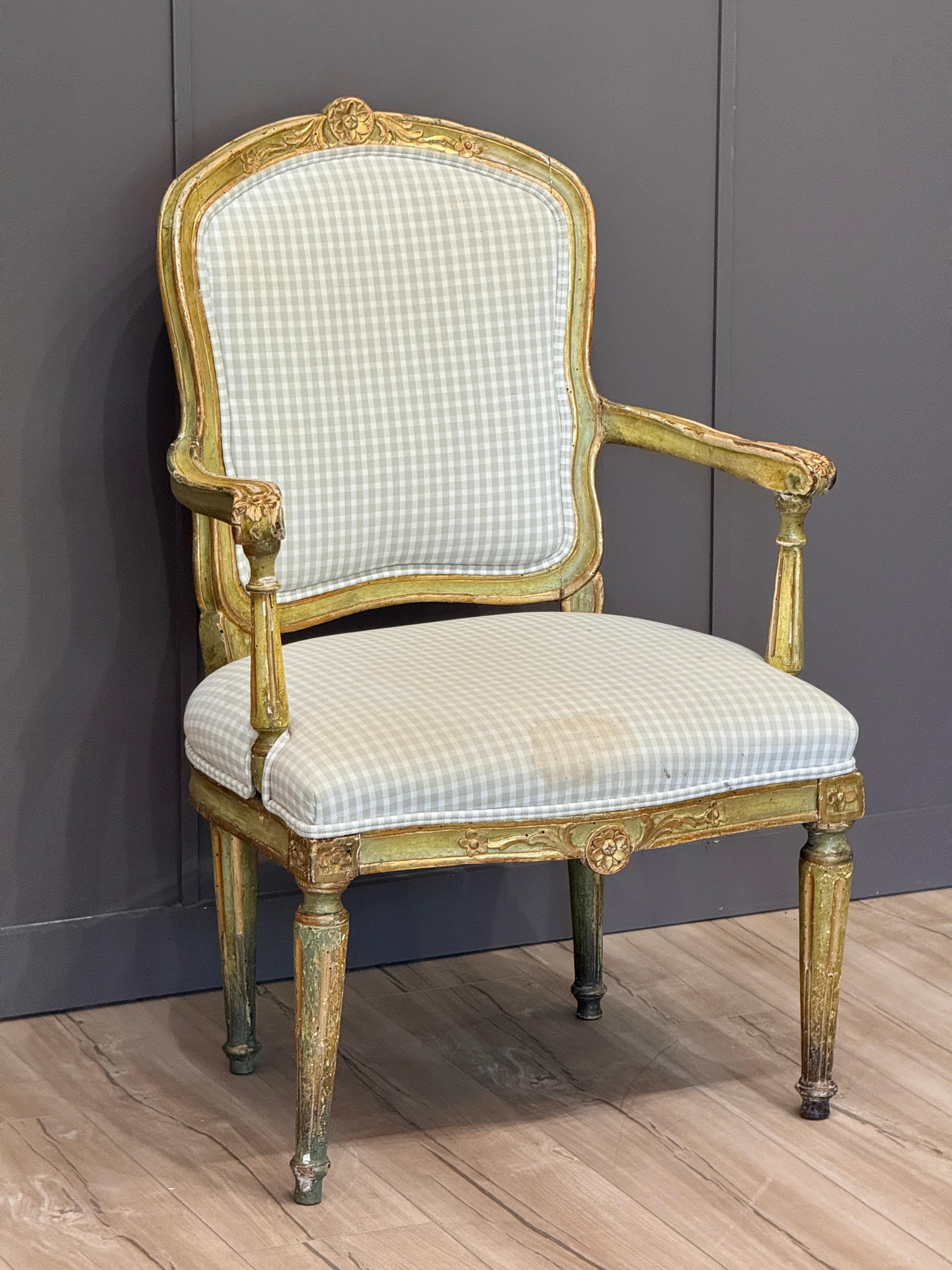 Fauteuil classique italien de la fin du XVIIIe siècle, qui conserve une surface attrayante peinte en vert et dorée à la main. Le cadre présente des détails floraux et des rubans finement sculptés, des pieds cannelés et des accoudoirs paddés. La