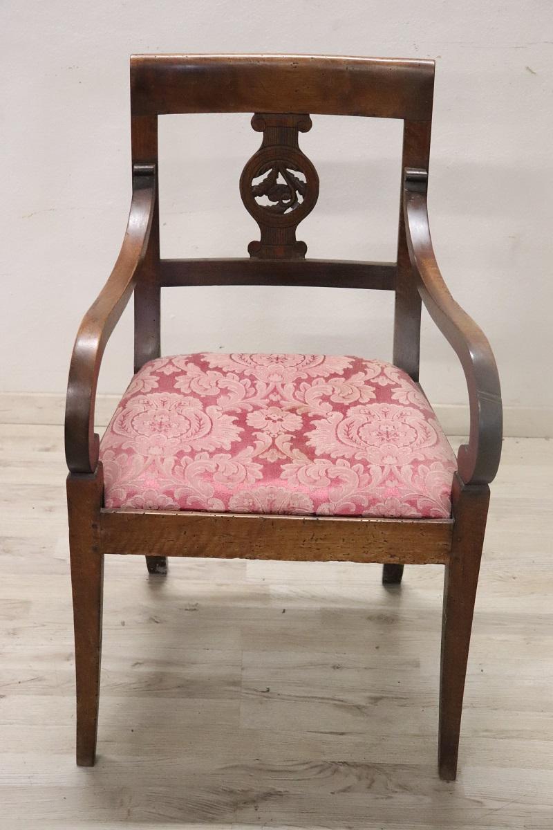 Beautiful late 18th century of the period Directoire Italian antique armchair in solid walnut wood. The armchair is very elegant. The backrest decorated with a carved in wood is beautiful, , two important curled armrests. The seat is padded and