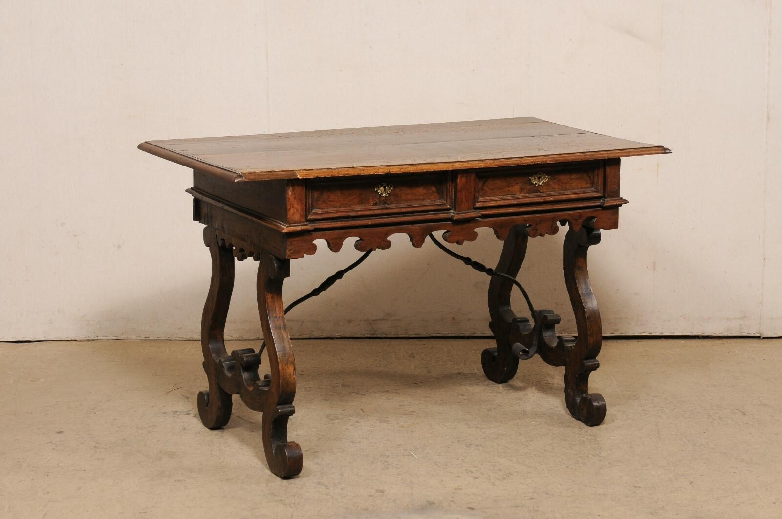 Table italienne en bois sculpté à pieds en lyre et traverse en fer du tournant des XVIIIe et XIXe siècles. Cette table ancienne d'Italie, à la mode 