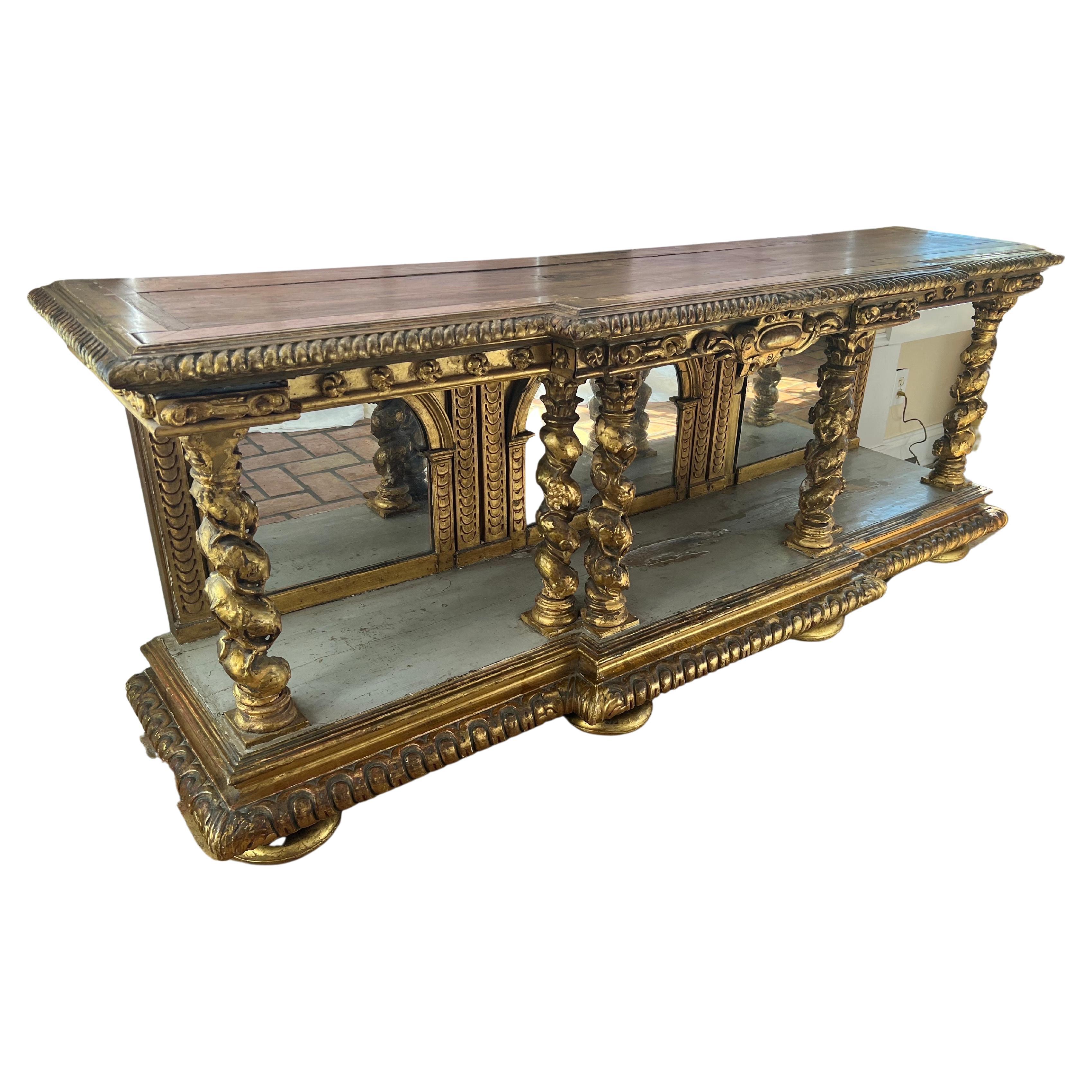 Neoclassical Italian Gilt Console with Mirrors. Late 18th Century Italian Gilt wood Gesso console or credenza. Triptych mirrored back with elaborately carved and turned grape vine columns. Most likely watergilded but some touch up to the gilt. Most