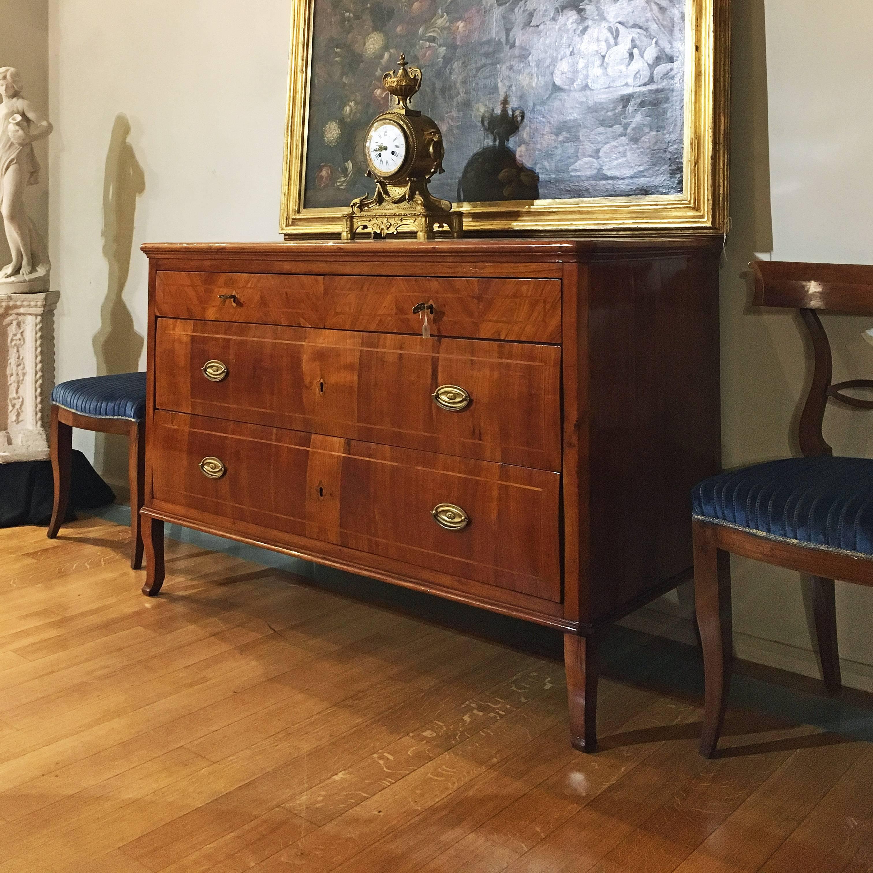A beautiful Italian chest of drawers or commode in solid walnut wood with inlays in walnut and fillets in palisander. Shaped front, with four drawers. The bronzes of the locks and the keys are original, Venetia, end of the 18th century.