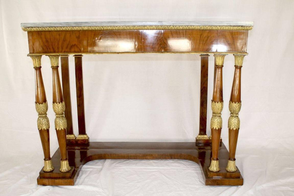 Italian neoclassical pier table covered in varnished book-and-end matched deep grained birch veneer with hand-painted gold acanthus friezes along the top outer edge and also around the four solid birch columns supporting the front of the table. The