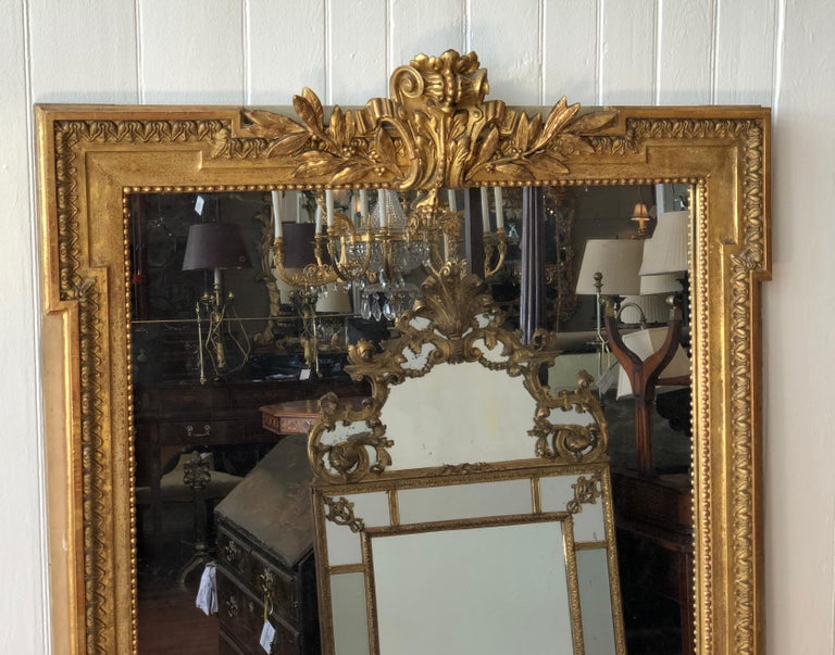 Magnificent late 18th century Italian neoclassical carved giltwood mirror, circa 1790. Carved wood and gilt stylized shield flanked by Olive Leaves. The frame has a polychromed cream edging and the main portion of the frame has a lotus motif with a