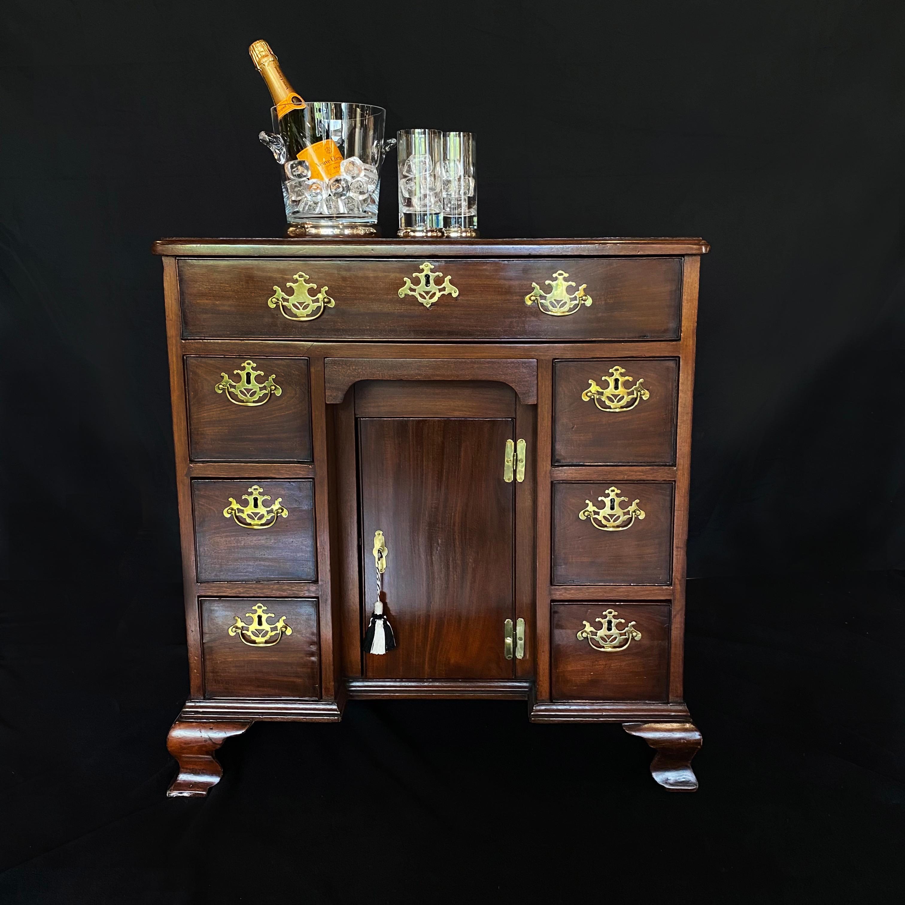 A spectacular late 18th century mahogany kneehole desk. A beautifully handcrafted desk with seven drawers and one cupboard, the piece comes with the original key. The drawers feature stunning original brass handles, typical of the George III period.