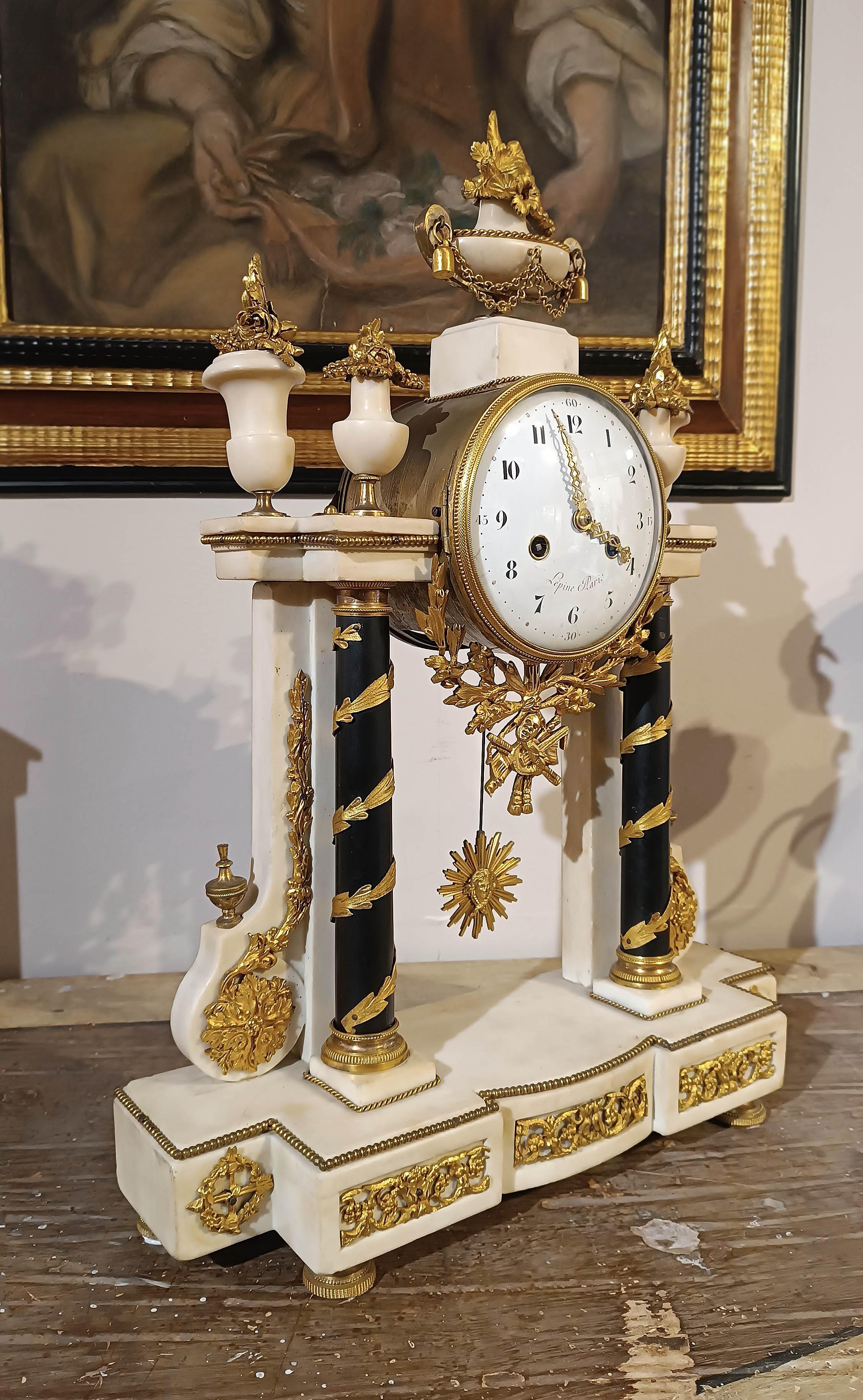 Un orologio da tempio raffinato e di grandi dimensioni. L'orologio presenta una cornice in marmo bianco statuario, decorata con colonne in marmo nero belga e partizioni in bronzo a cera persa finemente dorate. Le decorazioni richiamano lo stile