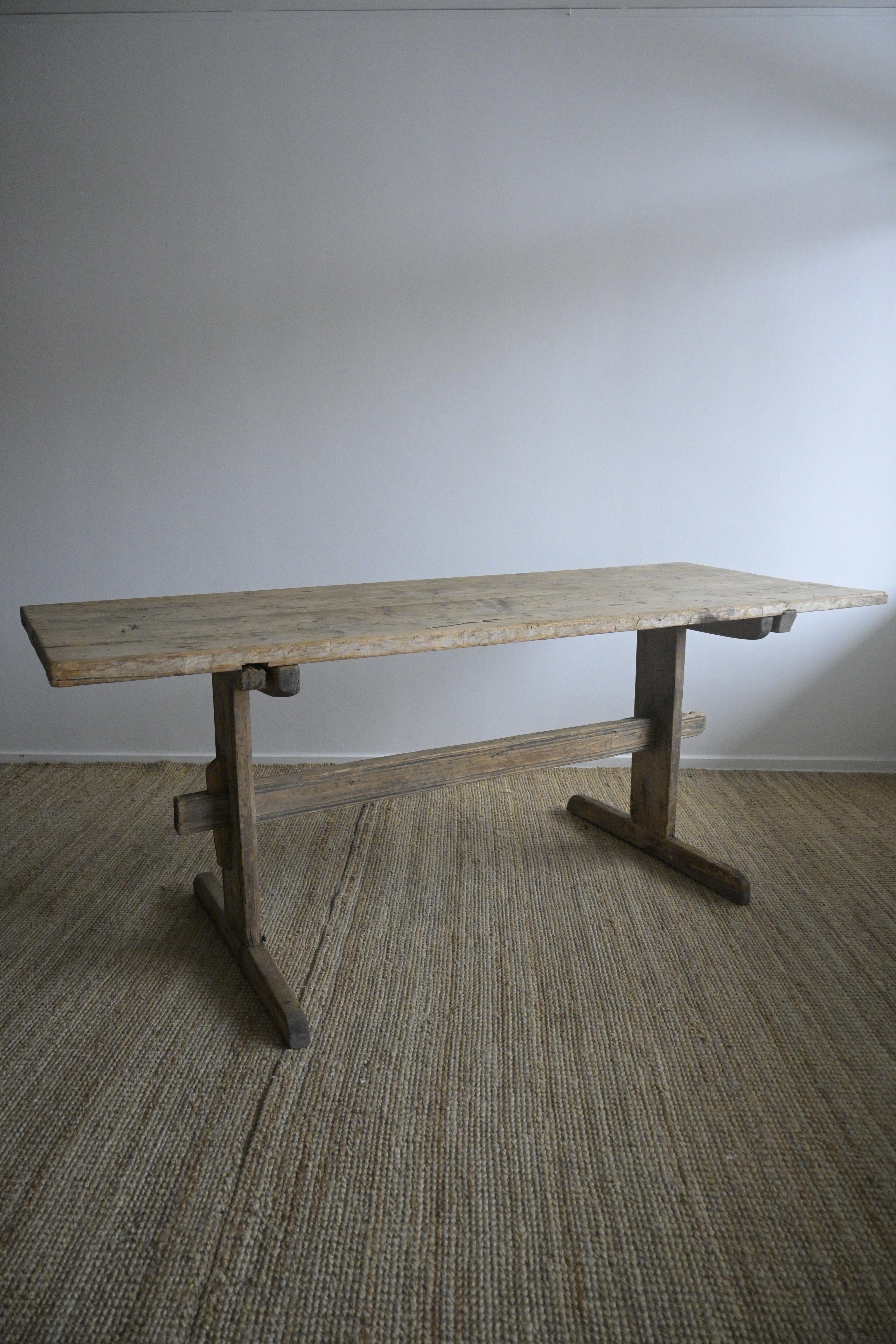 Late 18th-century long Trestle Table from Sweden.

Time has passed and has come again. The patina and wear over the centuries have made it into what it is today.

The tabletop has nicks, marks, and old beautiful natural cracks, and also has