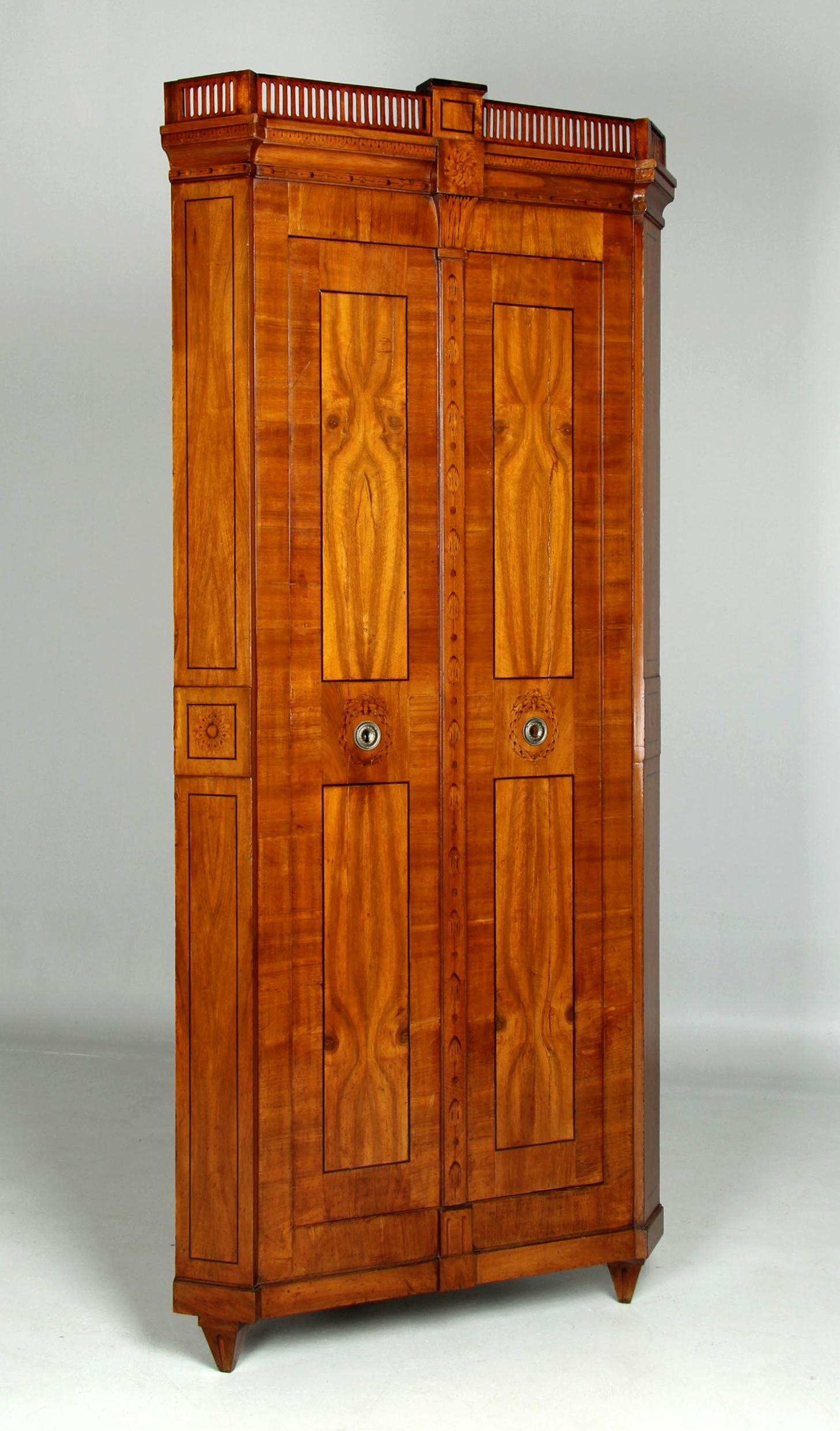 Louis XVI Eckschrank mit Intarsien

Süddeutschland
Nussbaum, Ahorn
Klassizismus um 1790

Abmessungen: H x B x T: 222 x 98 x 55 cm, Seitentiefe: 66 cm

Beschreibung:
Schlanker und wohlproportionierter Eckschrank aus dem süddeutschen