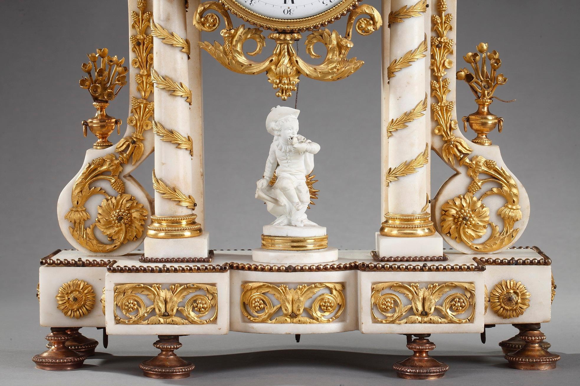 Louis XVI-period portico clock crafted in Carrara marble accentuated by exquisitely detailed ormolu decoration of garlands, flowers, vases, acanthus and laurel leaves. The drum case is supported on a pediment raised on two free standing columns and