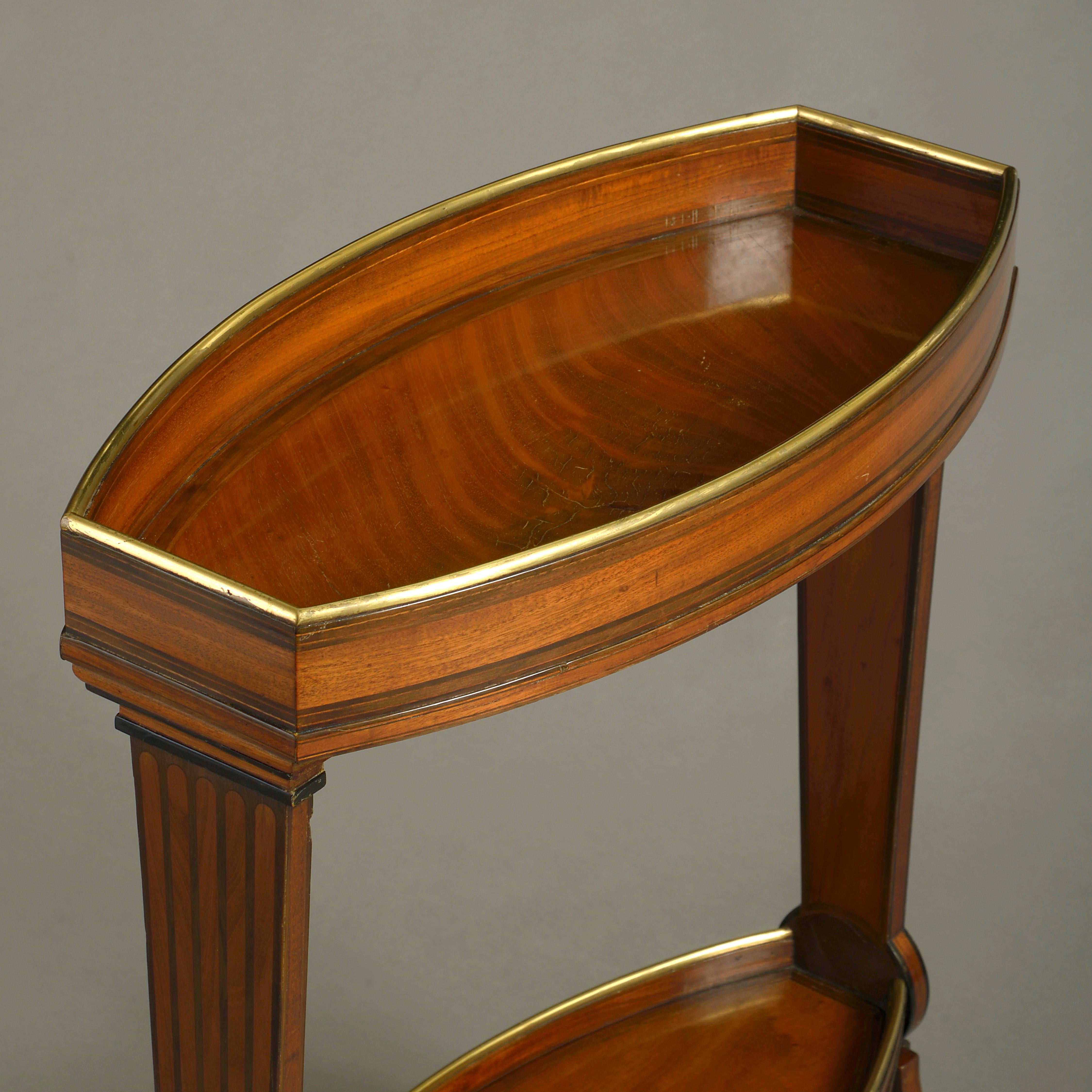 A very fine late 18th century Louis XVI Period mahogany jardinière, the concave brass mounted rectangular top having inlaid sides and set upon tapering supports with inlaid boxwood fluting, the corresponding brass mounted lower shelf upon scrolling