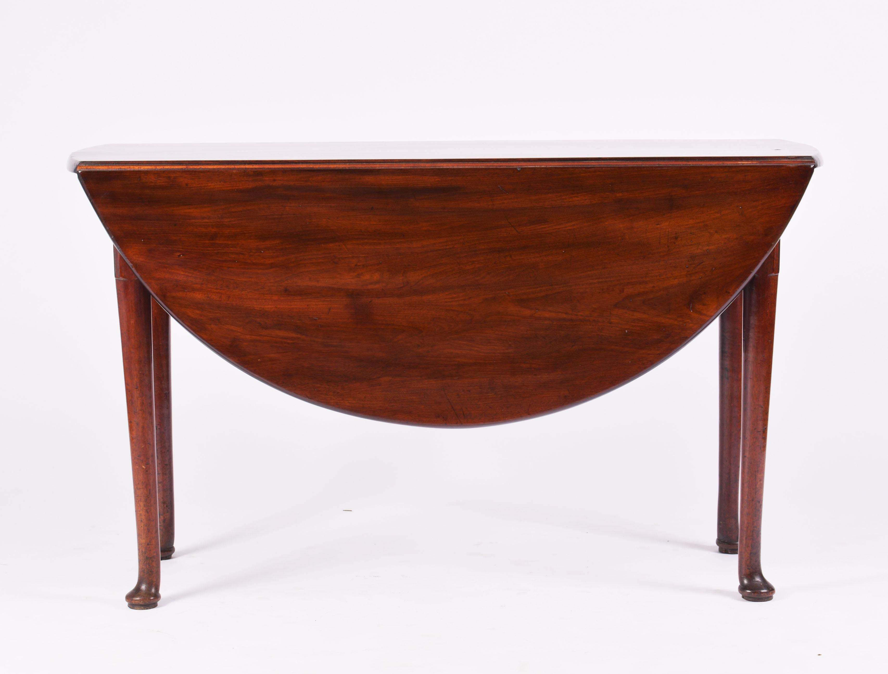 This beautiful and well- proportioned mahogany drop leaf circular table features a gorgeous rich deep patinaed grain and supported on tapered legs with pad feet. The table measures 16 ¾ in – 42.5 cm wide with both sides down and 48 in – 122 cm in