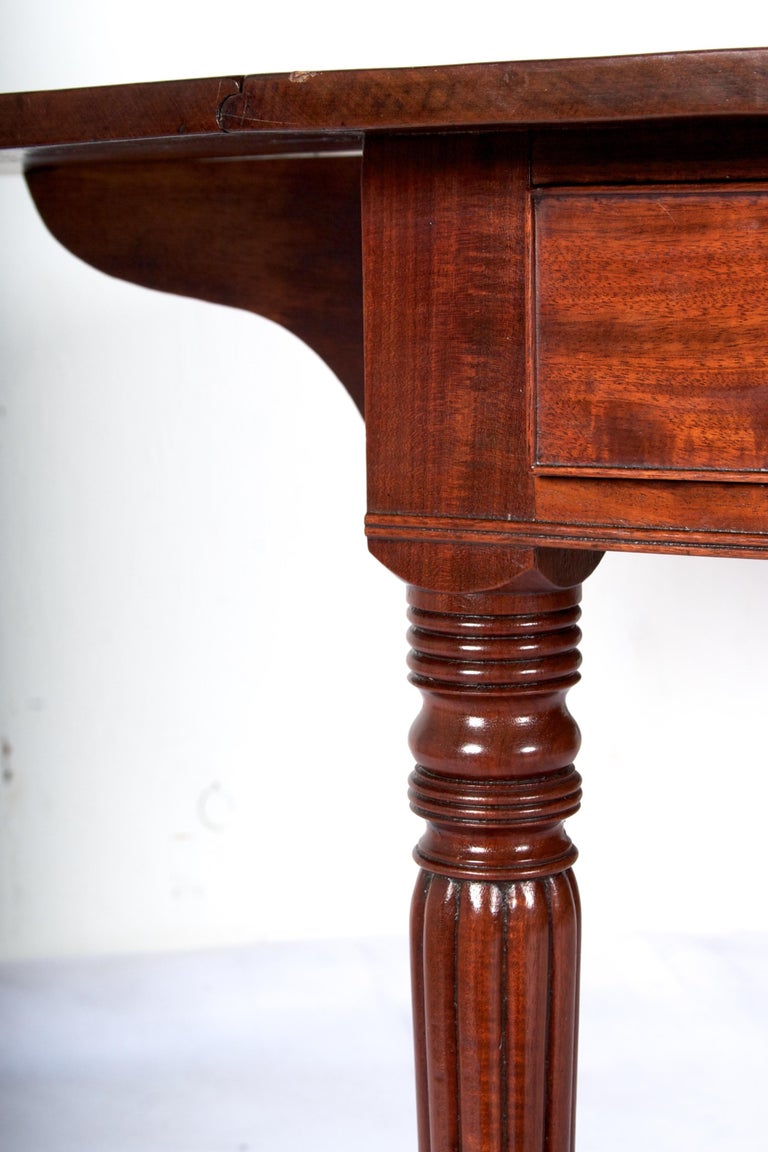 Very fine mahogany and superb craftsmanship set this pembroke
dining table apart. The table has never been refinished, there is
some sun fading on one side on the outer portion of the legs.
This fading will be restored at no charge should the