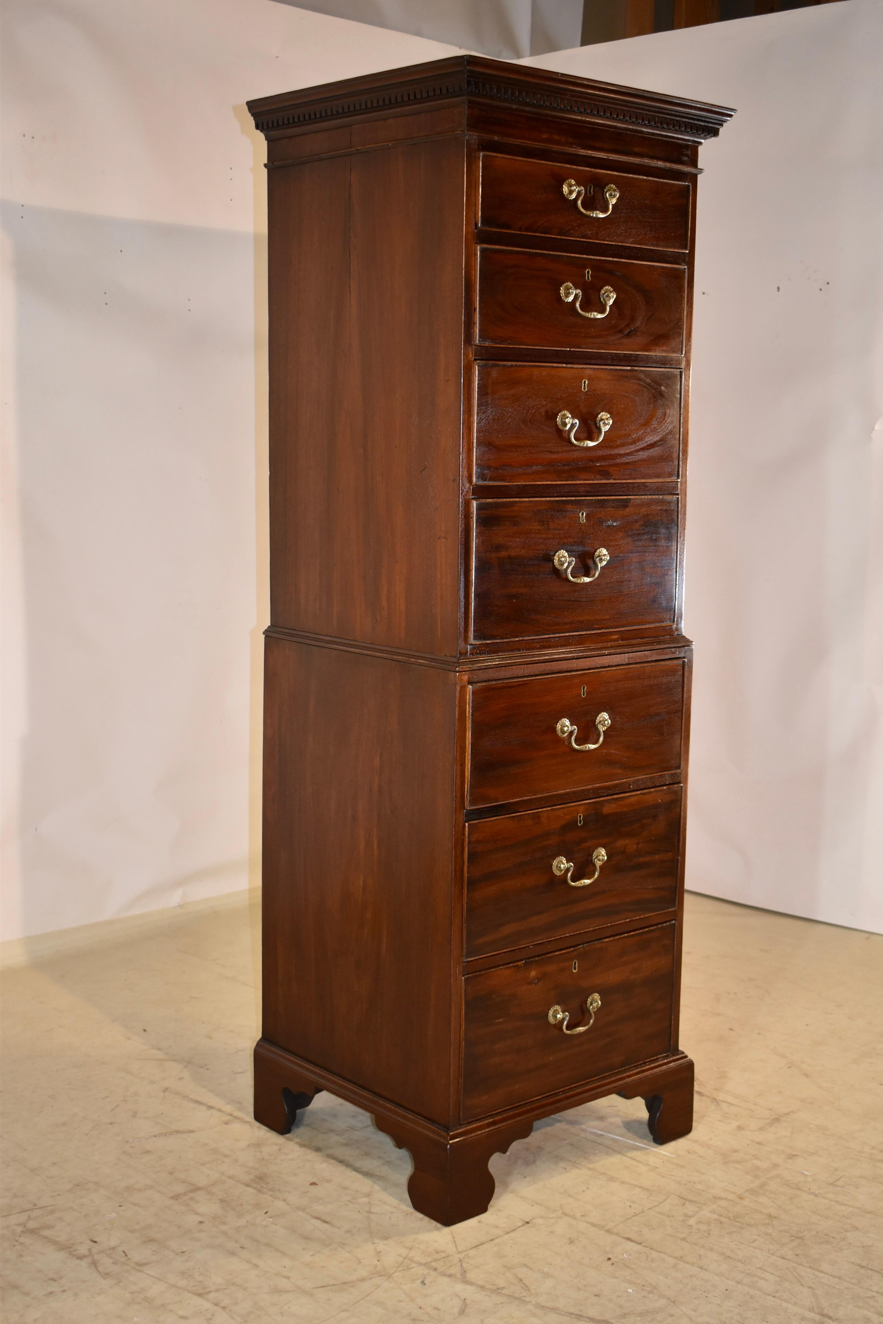 Late 18th or early 19th century English single tall chest made from mahogany.  The top has a crown over a dentil molding, following down to simple sides.  The front of the case has four over three drawers.  The chest is made in two pieces, for easy