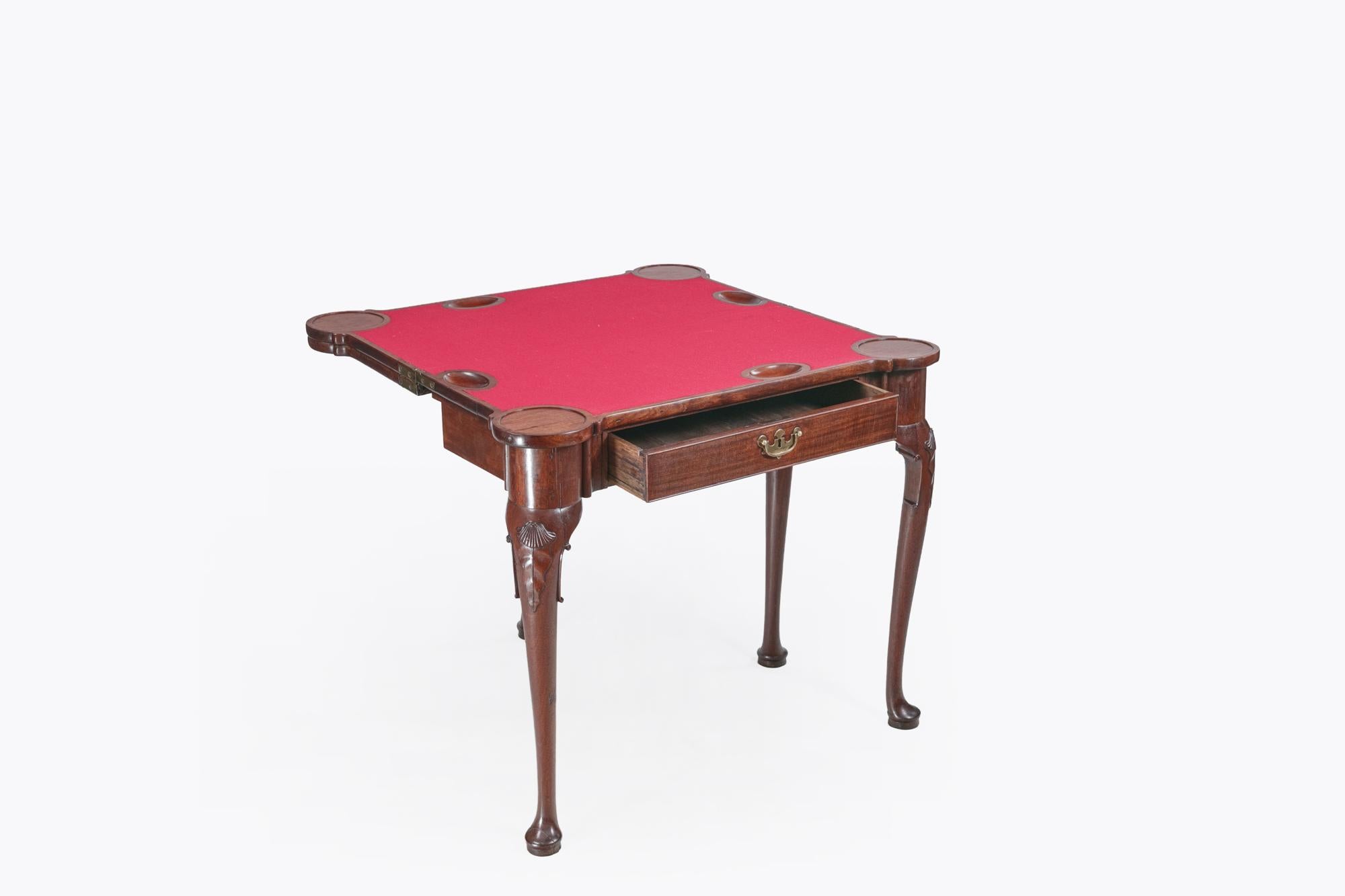 Late 18th Century mahogany triple top fold over card table which opens to reveal a playing surface. It features surfaces for both a game table with baize lining and sunken counter wells, as well as a tea table of the finest quality, to top. It