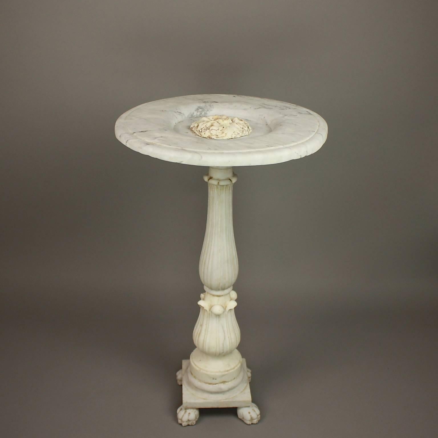 Late 18th century marble fountain carved in Carrara marble and originally the center piece of a larger basin. A circular flat top with a central vine ornament adorns the waterspout. The water would pour over the rim softening the edges of this hard