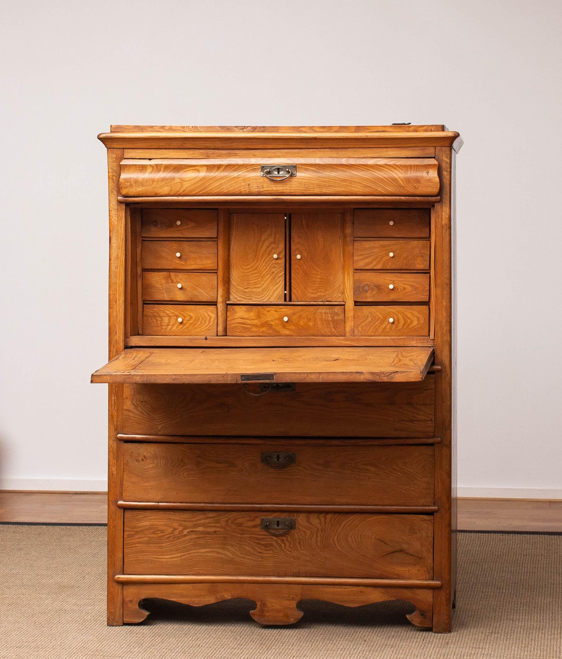 Beautiful and in fully original condition Swedish pine secretaire features rounded corners with a curved drawer on top and beneath a key-locked fall front, which opens to reveal a writing surface and a fitted Swedish pine interior. The interior is