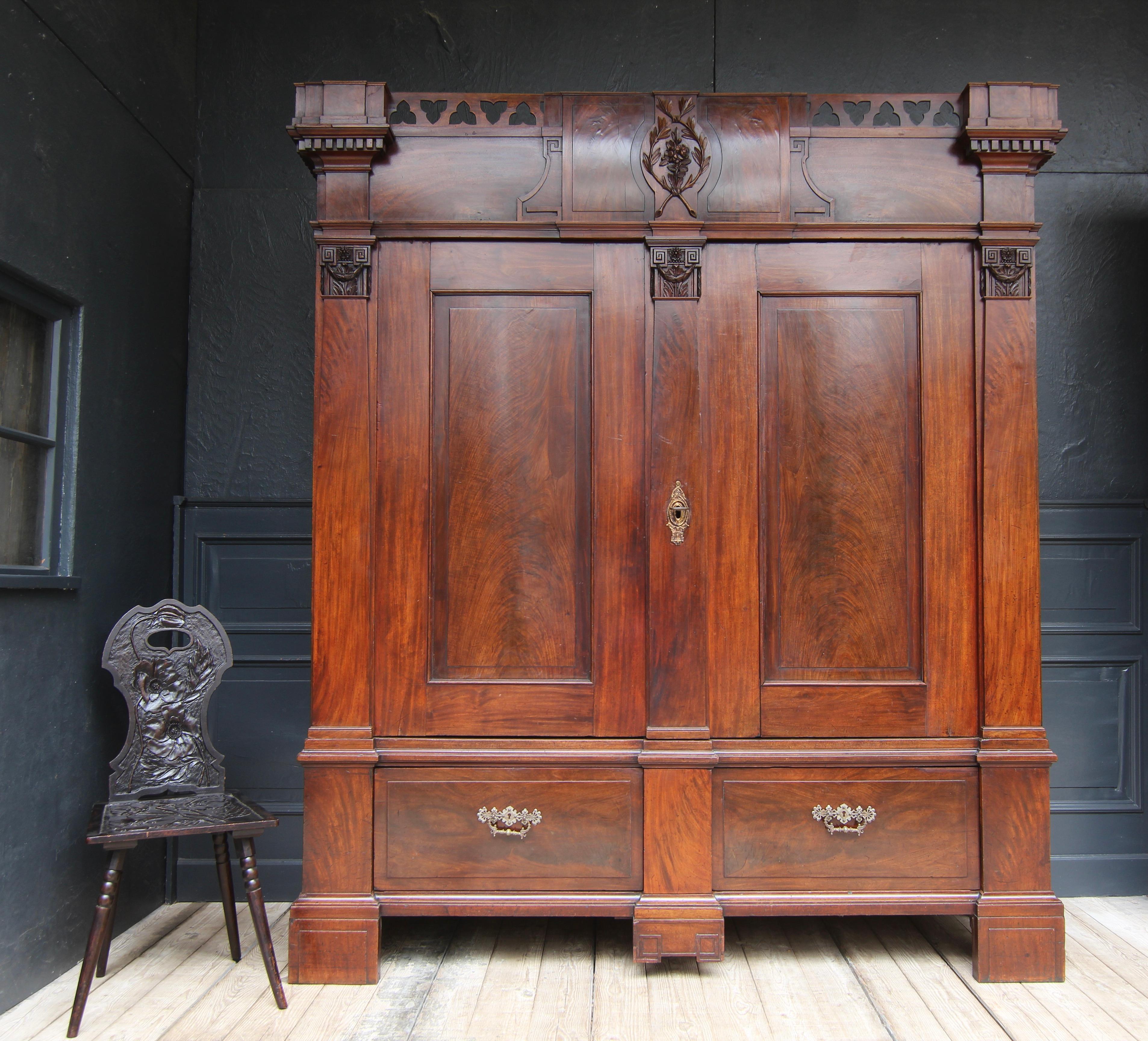 Cabinet néoclassique datant d'environ 1800, Allemagne du Nord/Pays-Bas. Acajou massif et placage de chêne. 

Armoire démontable à lignes droites, reposant sur 4 pieds montants, avec une façade divisée verticalement par 3 pilastres.

Haut socle à