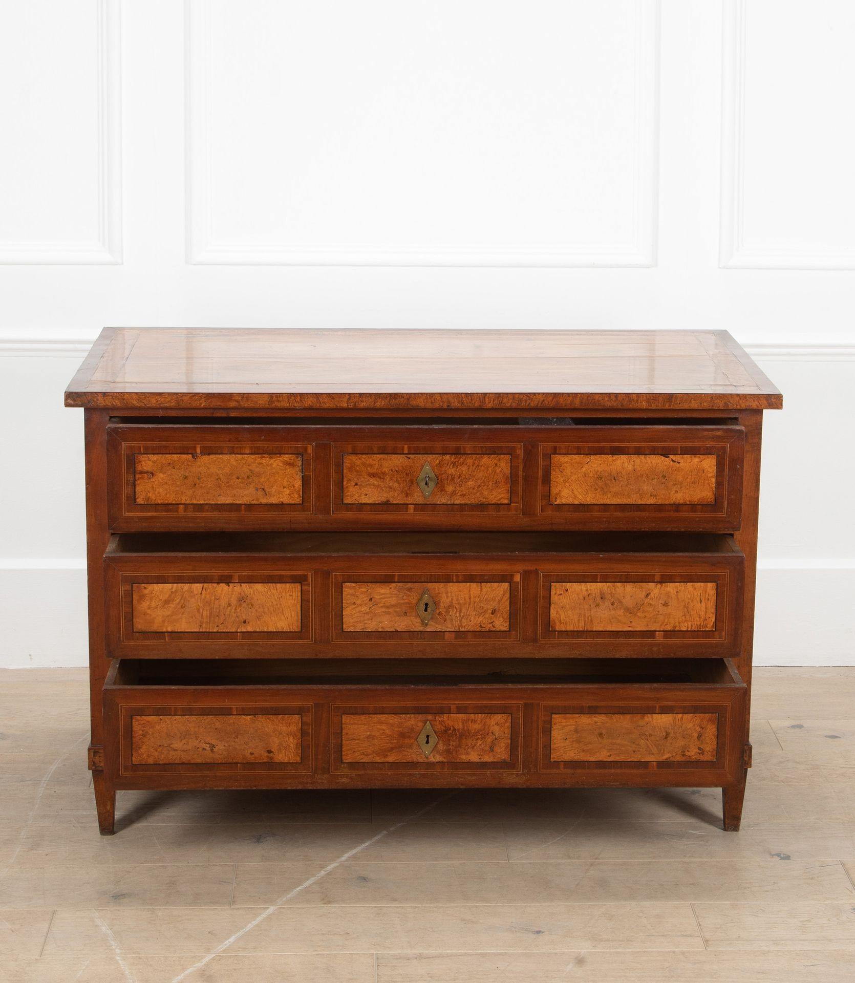 Commodo settecentesco in frassino, tulipano e legno di re, di origine italiana.
Il piano presenta una profonda fascia trasversale e delicati motivi intarsiati agli angoli. Ha tre cassetti splendidamente pannellati con bordatura a tulipano,