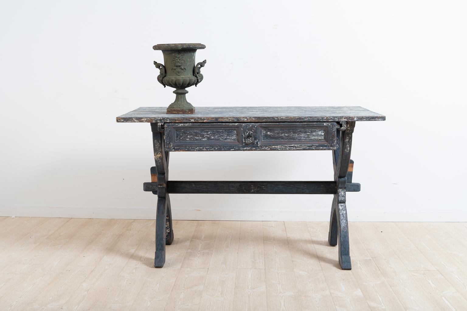 Blue folk art trestle table from northern Sweden. The table is made with a drawer and all parts are original to the table. Scraped to the original blue paint the table has charming distress and different tones in the paint which makes it interesting