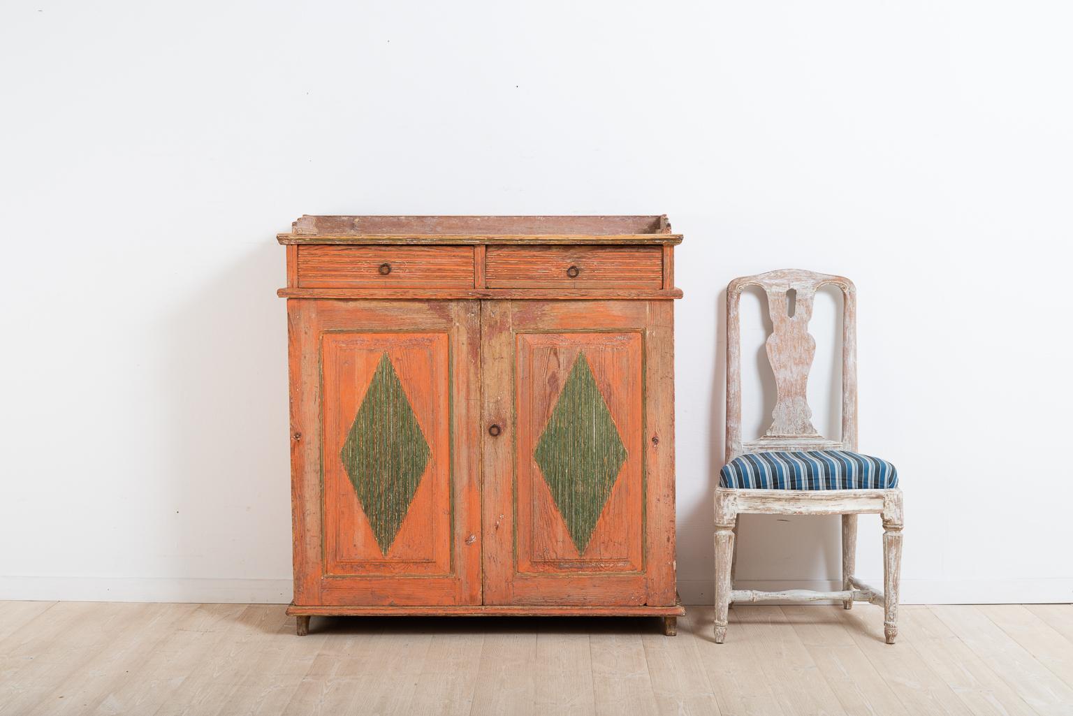 Swedish Gustavian sideboard dry scraped to original paint. The sideboard has decorative diamonds on the doors, painted green for additional contrast. The hinges are newer and were most likely changed during the mid-19th century. The sideboard was
