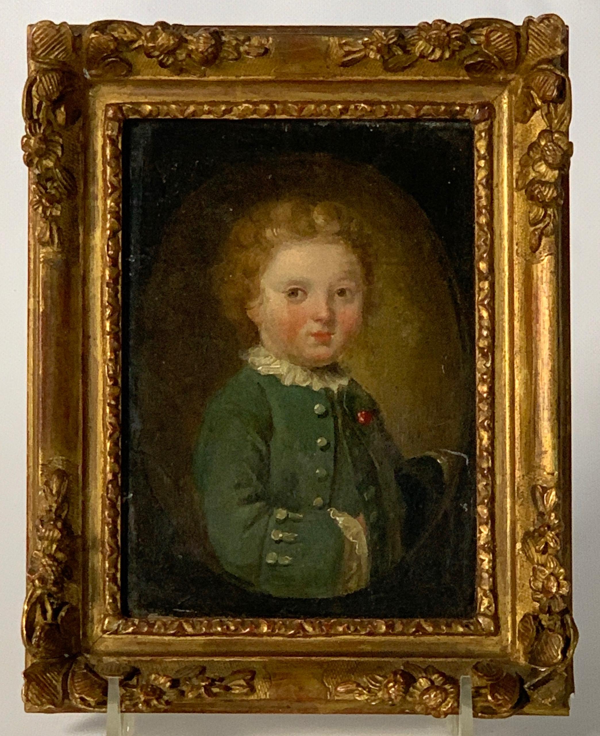 A charming late 18th century English oil on canvas miniature portrait of a boy laid on masonite board in early, perhaps original, beautifully carved gilt wood frame.
