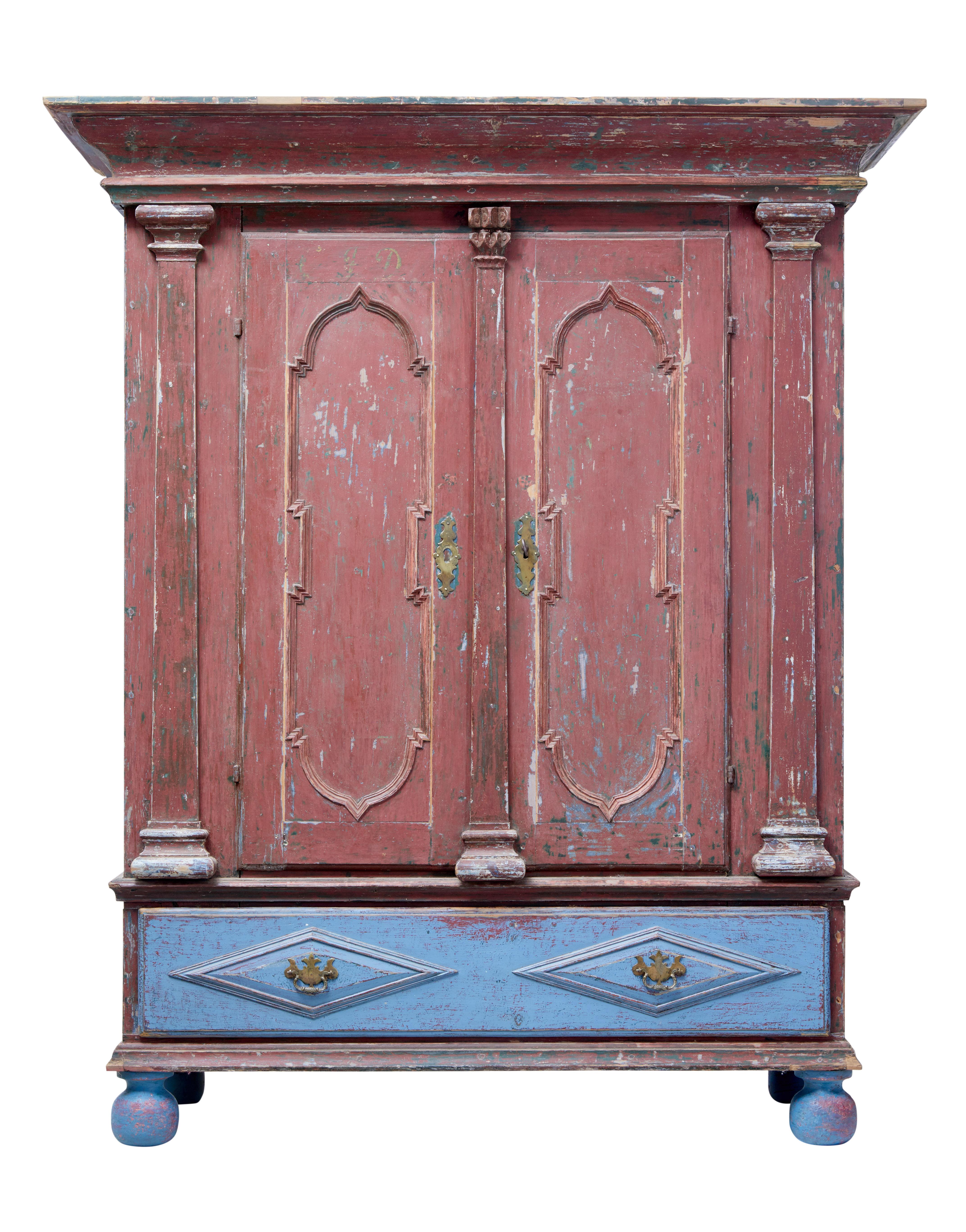 Substantial rustic Swedish baroque influenced cabinet, circa 1799.

Dated from very faded initials and date to the top of the doors and presented in its original scraped back paint.

Large over sailing cornice, below which a double door cupboard
