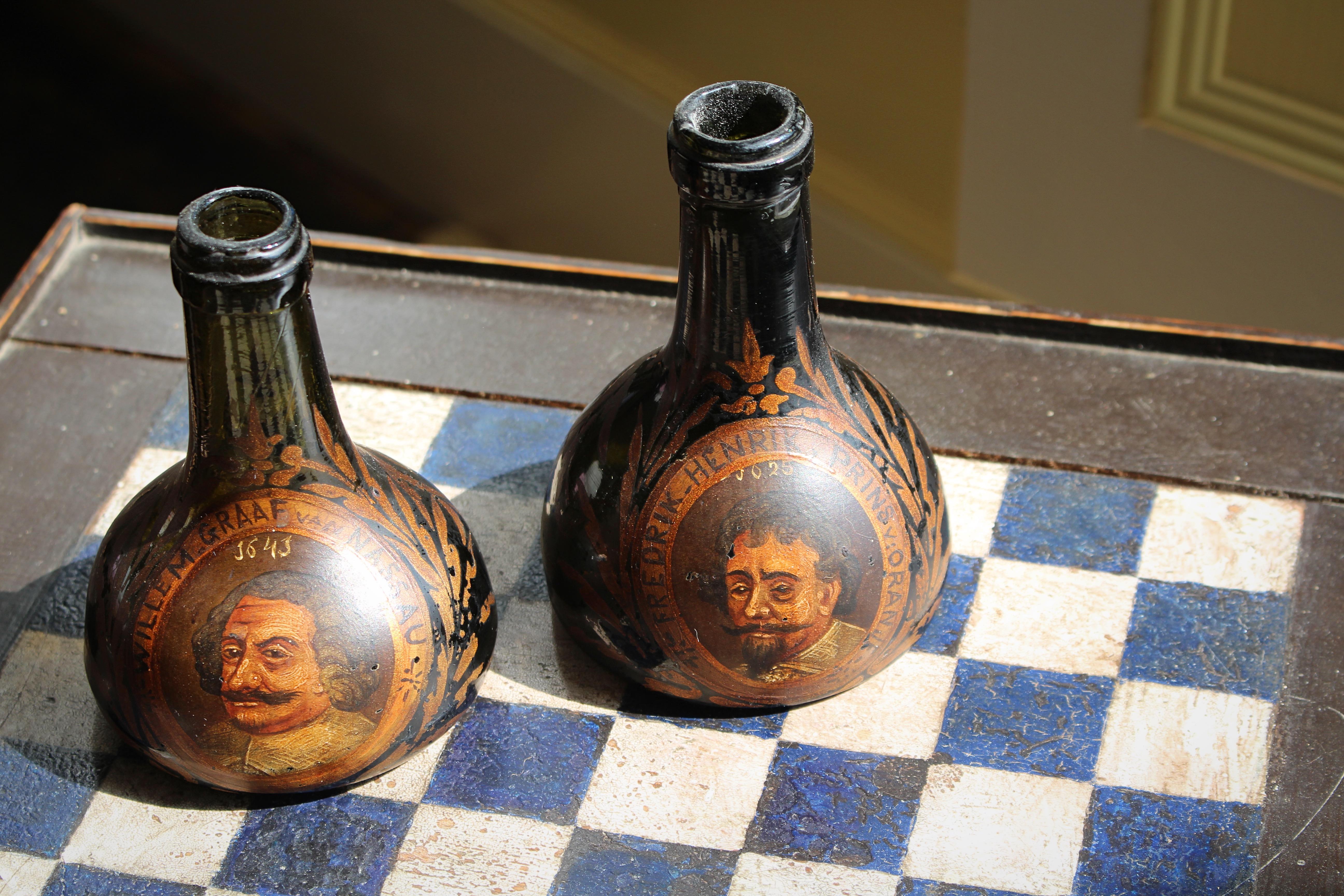 Una coppia decorativa di borracce in vetro dipinto, probabilmente in origine per il gin.

Dipinti a olio all'esterno, ciascuno con un bel ritratto di un nobile olandese e uno stendardo/stemma di famiglia sul retro.

I nomi di ciascun gentiluomo