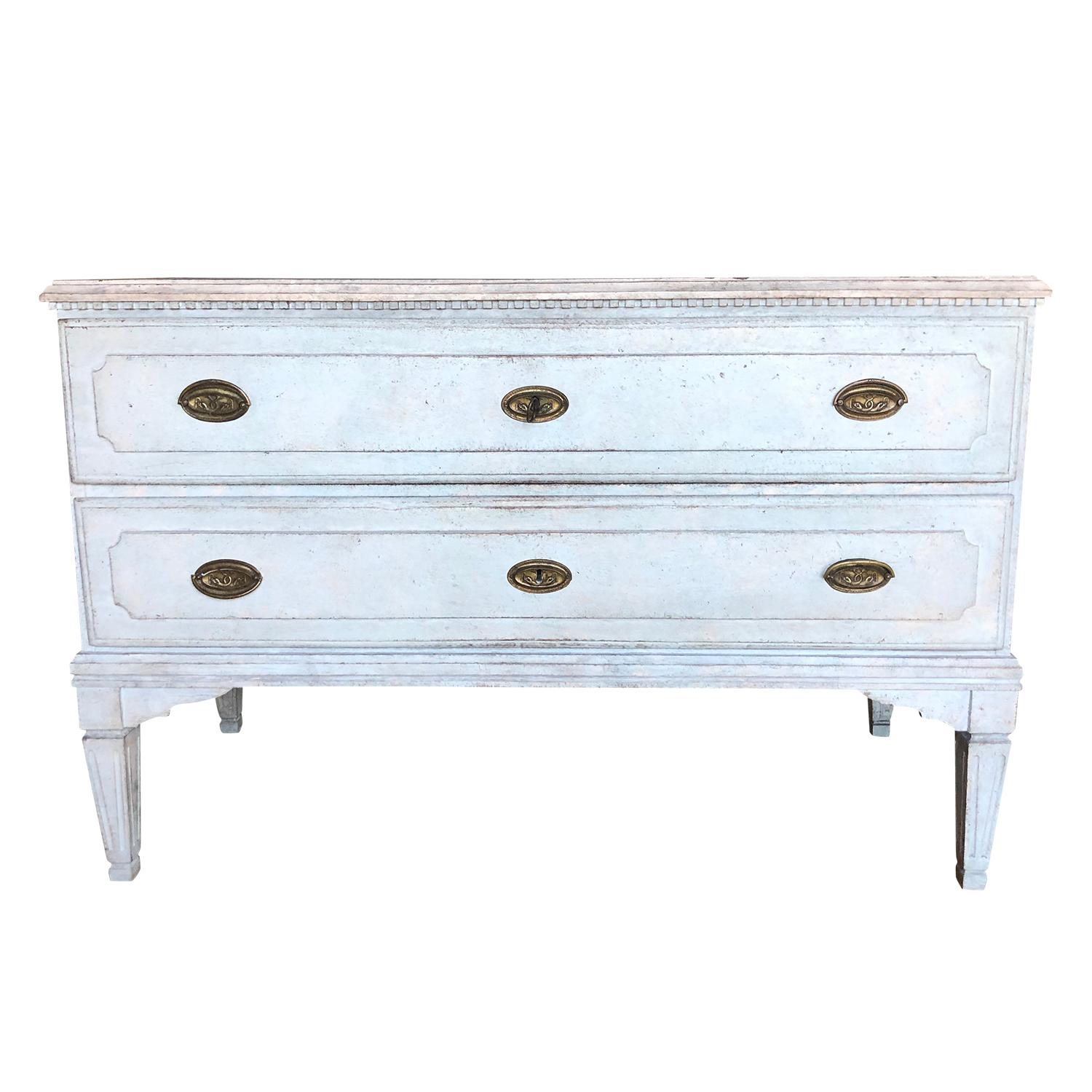 An antique pair of Swedish Gustavian chests with two drawers each, made of hand carved oakwood, supported by four straight tapered feet, in good condition. The light-blue, Scandinavian cabinets are detailed in the neoclassical Greek style with their