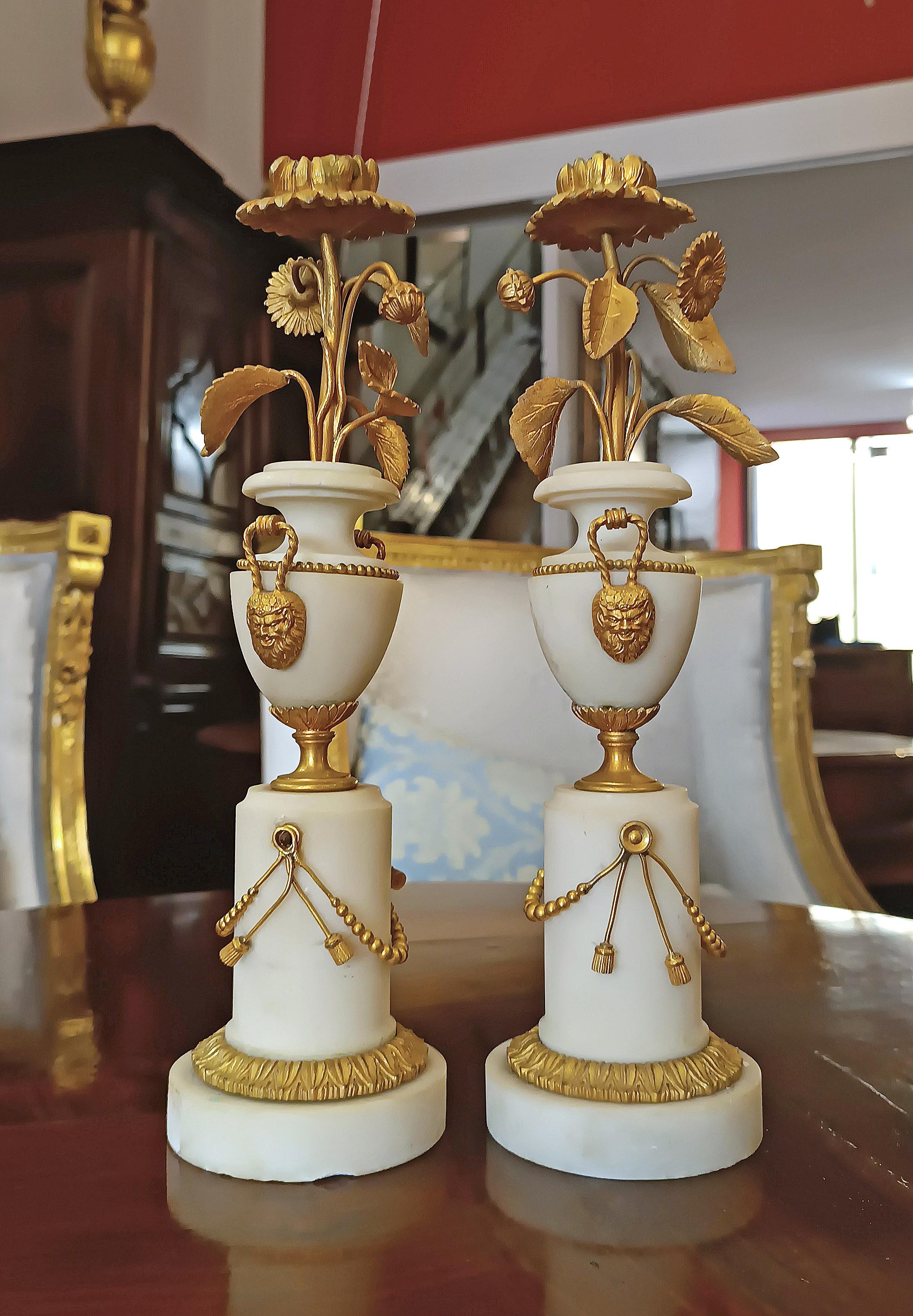 Élégante paire de chandeliers à une seule lumière, fabriqués en marbre statuaire et en bronze au mercure doré. Les chandeliers sont dotés d'une haute base sur piédestal et d'un corps en marbre en forme d'amphore, enrichi de décorations en festons et