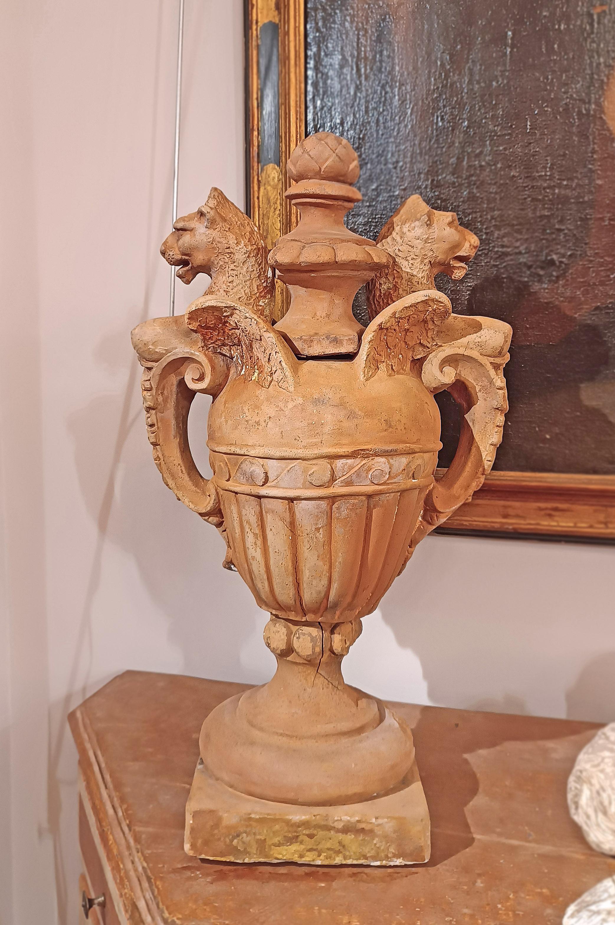 Pair of terracotta vases, made with a stick. The vases have a square base, a globular body decorated with raw engravings. The handles, of great originality and characteristic, are decorated with leaves at the base and end at the top with winged