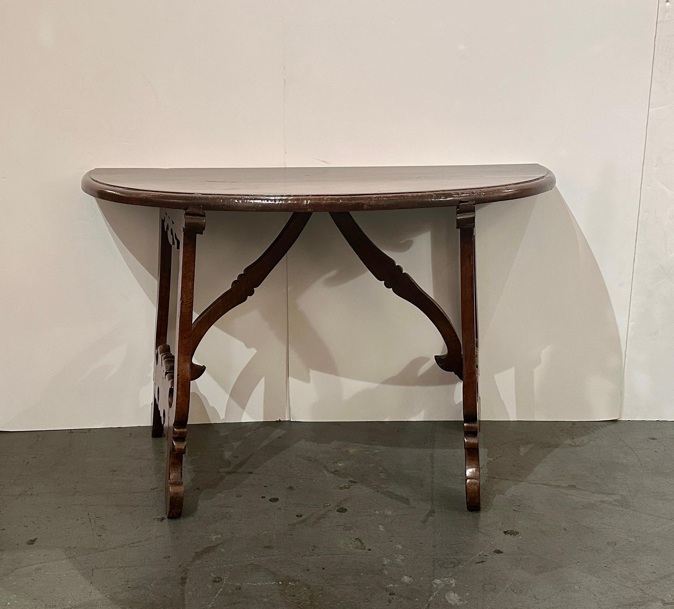 
Paire de consoles en noyer, sculptées à la main, en demi-lune, avec des pieds en forme de tréteaux.  
