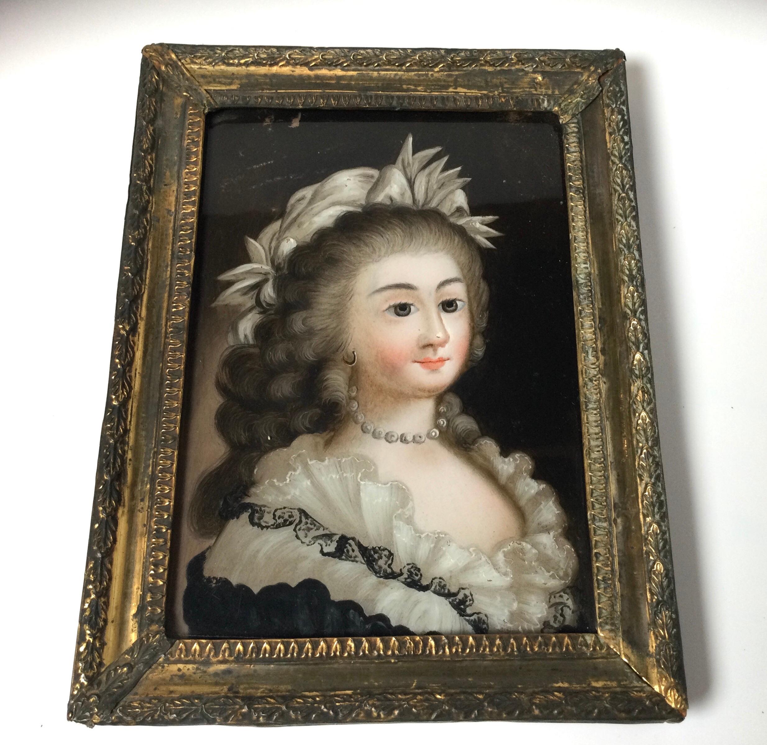 A Chinese Export late 18th century reverse painting on glass portrait of an aristocratic lady in fine costume. Complete with original tin clad wood frame. The frame with some remains of the original gilt. Measures: 10 inches high, 8 inches wide.