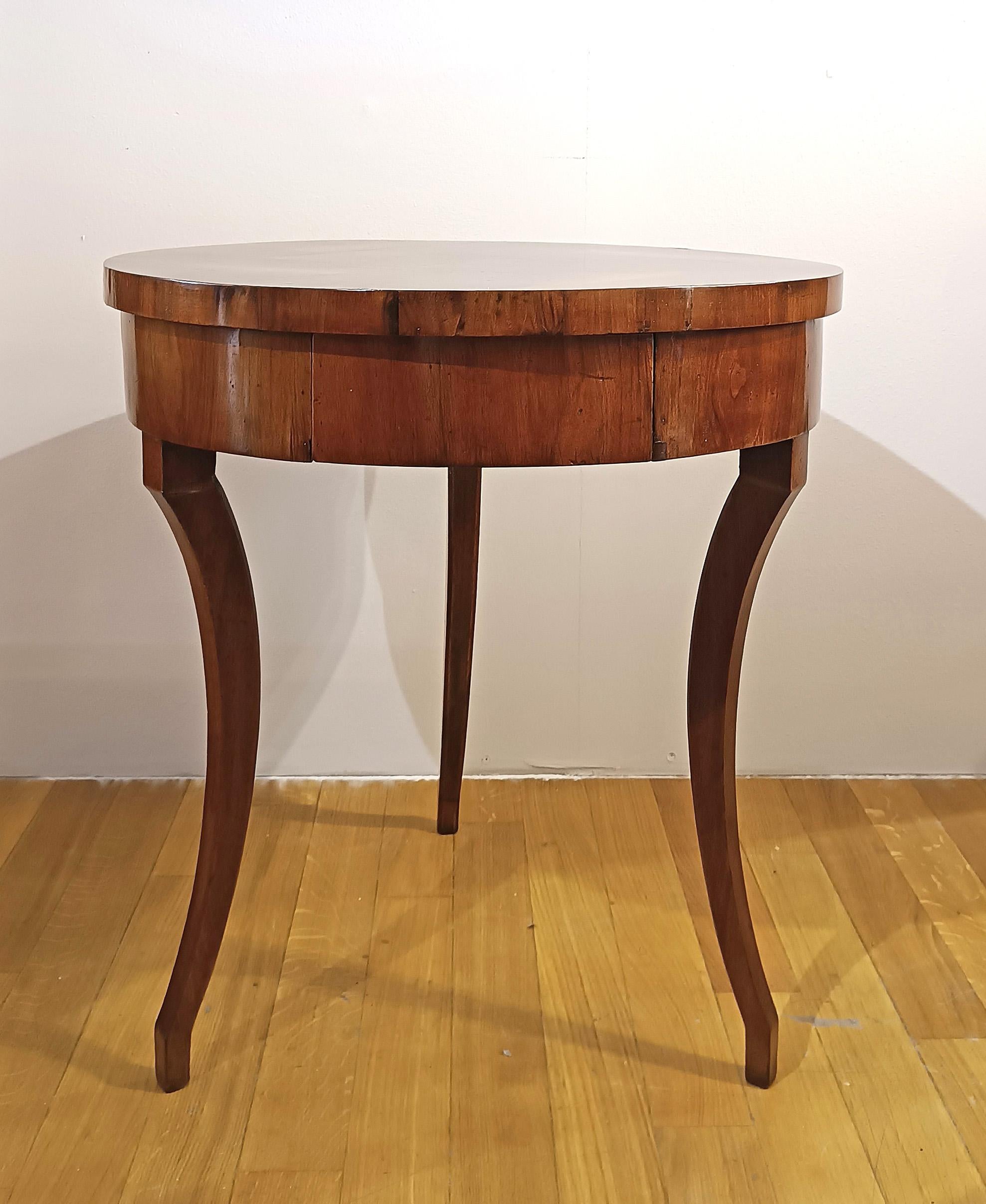 Elegant coffee table embellished with solid walnut legs and a poplar top veneered with walnut. The legs feature curved saber shapes, typical of the period, while the smooth top is enhanced by a wide band beneath the top, both featuring refined