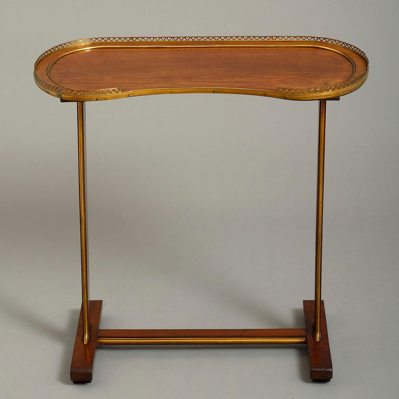 A late 18th century Russian brass-mounted mahogany table, the galleried kidney-shaped top raised on trestle supports.