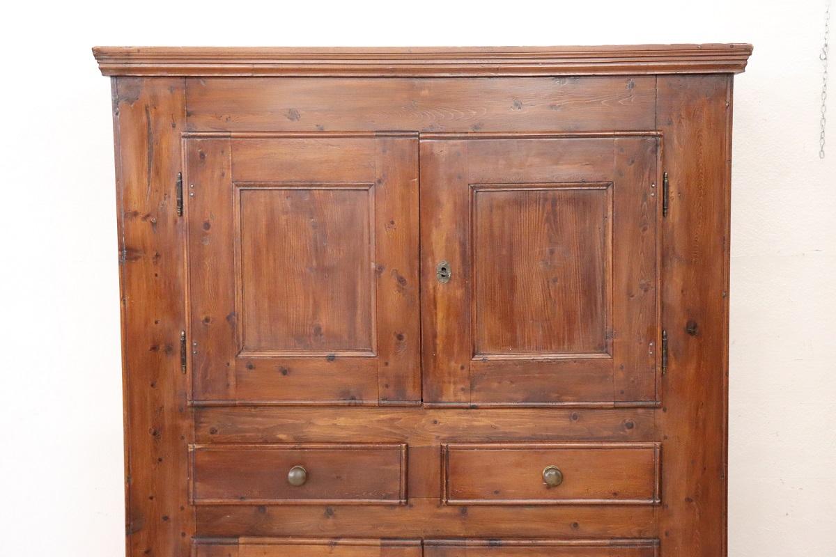 Seltener antiker Schrank aus massivem Tannenholz aus dem späten 18. Jahrhundert, Italien.  Charakterisiert durch eine rustikale und wesentliche Linie, mit vier kleinen Türen auf der Vorderseite und zwei praktischen Schubladen in der Mitte. Großer
