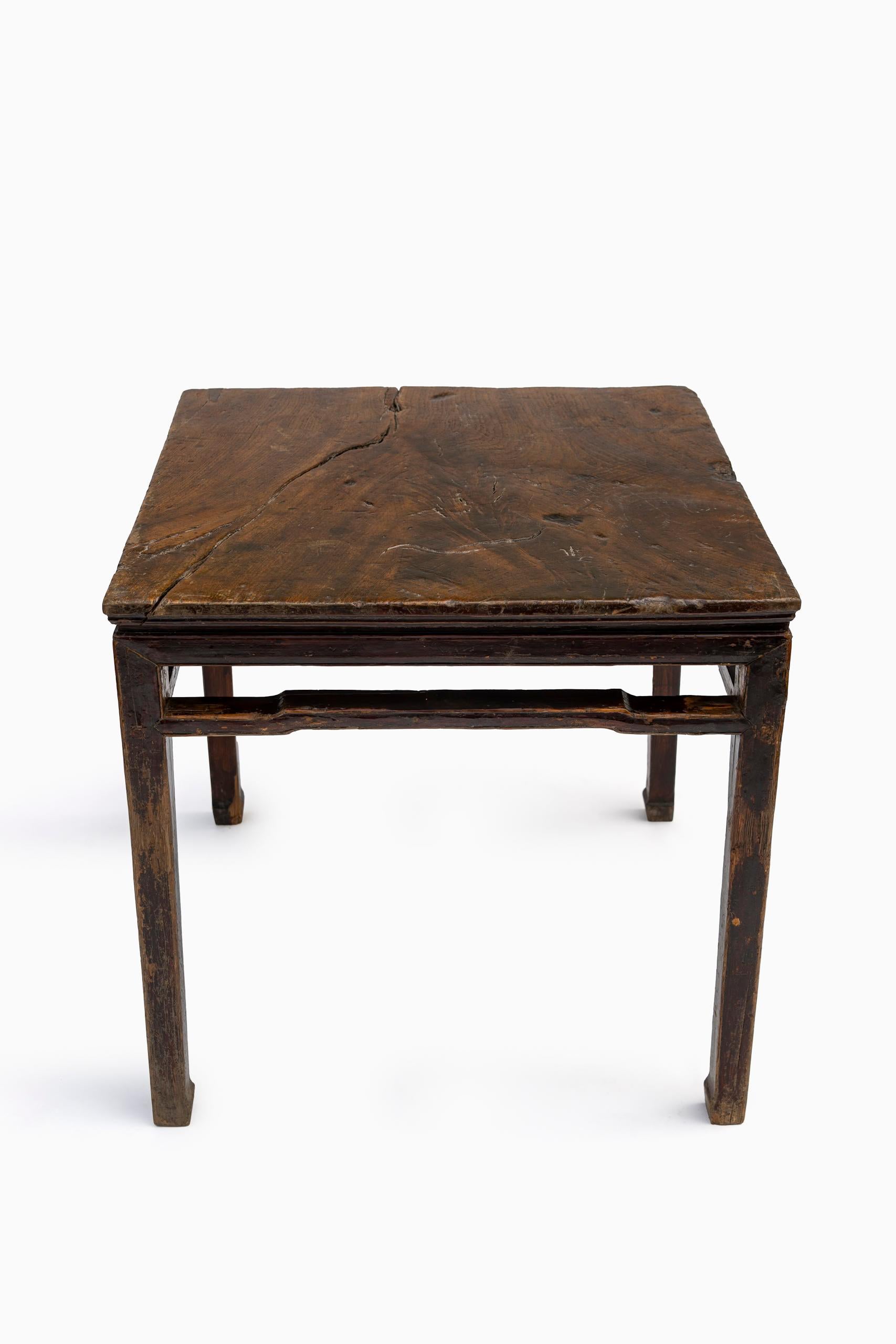 An 18th-century Chinese table in Elmwood,  retaining its rich. naturally aged patina. The table features a simple yet refined design with staight legs and subtly carved central apron, characteristic of Qing dynasty craftsmanship. Most likely was a