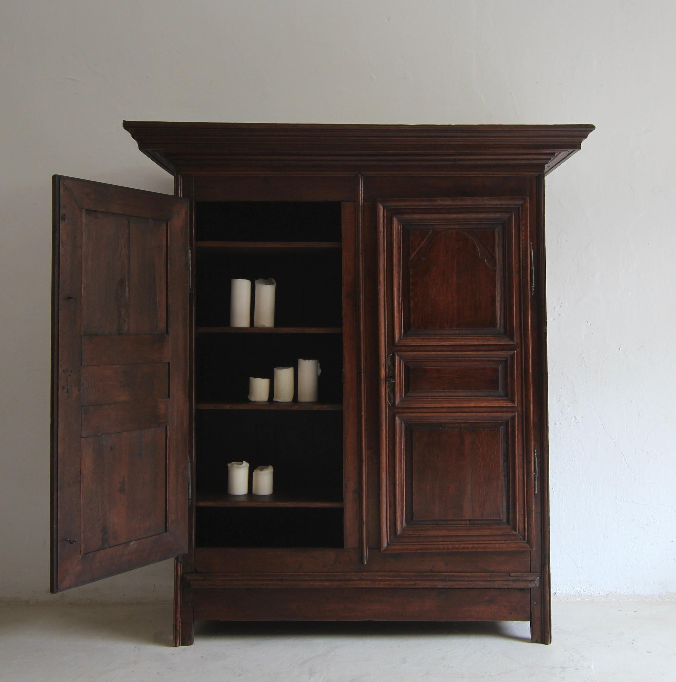 A late 18th century provincial cabinet, solidly made of oak. Ready for everyday use with beautiful original patina.

Traditionally crafted oak body, moulded on the sides, with 2 doors and a wide overhanging, multi-profiled cornice. The doors in