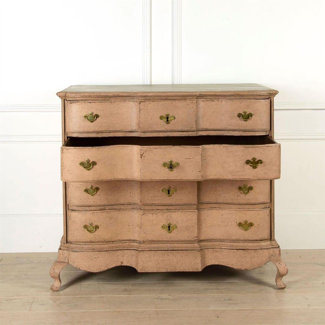A Scandinavian three-drawer chest of drawers painted in a calming shade of Peach Blossom with unusual base, faux-marble top, dovetail joints and curved drawers. Includes the original hardware (locks, escutcheons and handles). Sweden, circa 1780.