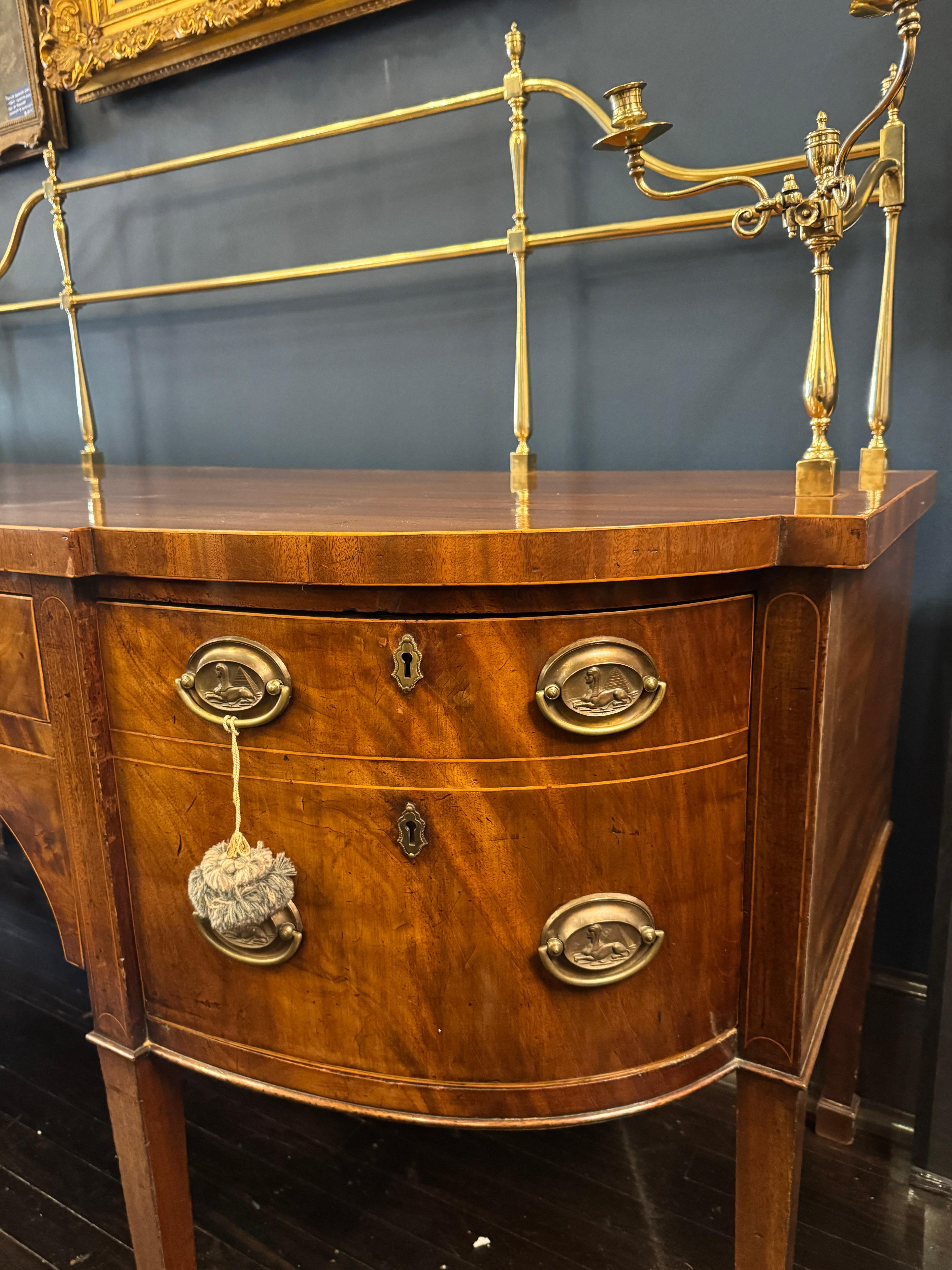 Credenza Sheraton inglese in mogano con guida in ottone della fine del XVIII secolo

Questo bellissimo pezzo è caratterizzato da un piano a serpentina con angoli e bordi decorati a linee, e da un cassetto centrale a fregio affiancato da cassetti per