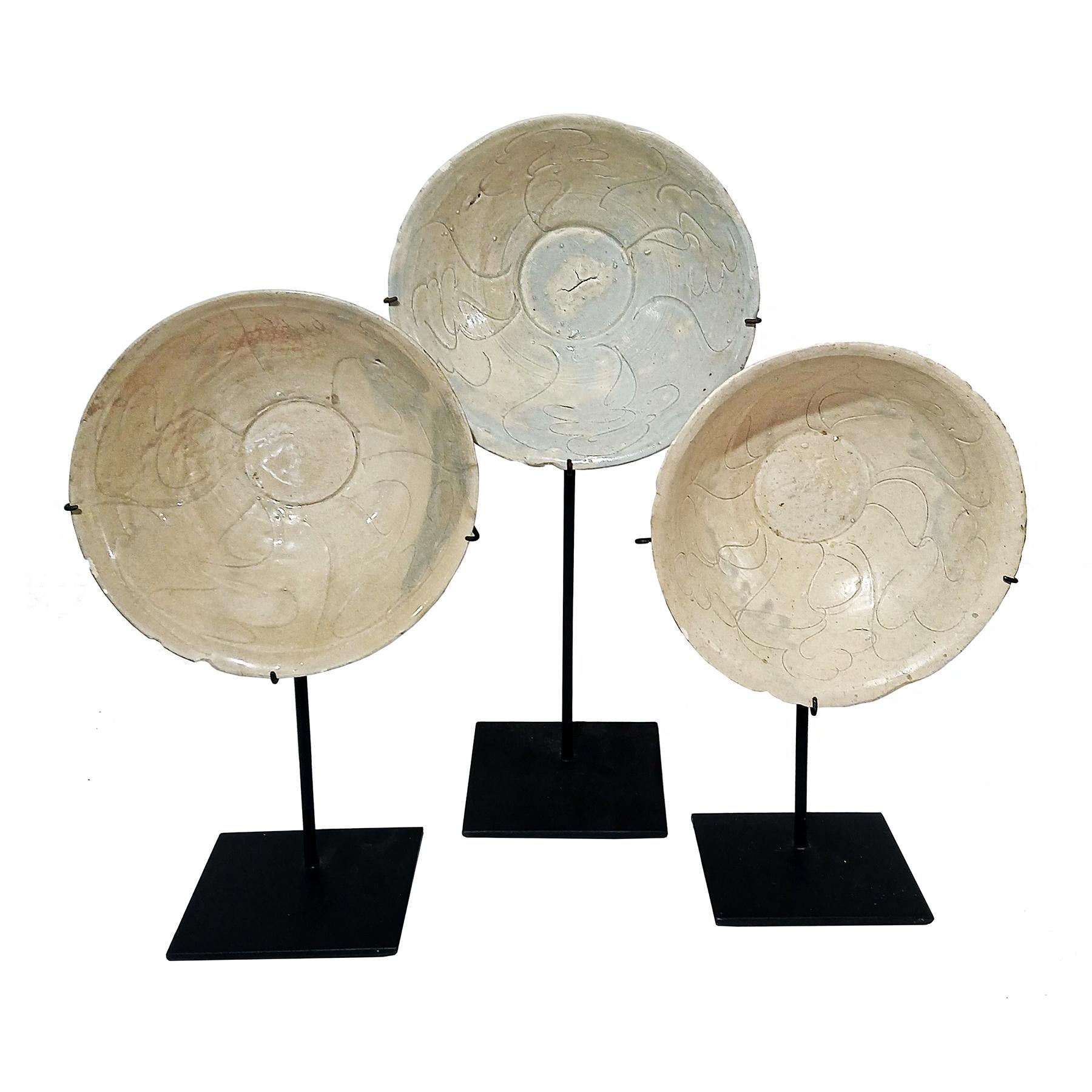 Three small ceramic bowls, reclaimed from a mid-19th Century shipwreck off the coast of Indonesia. 

Defying time, these plates were preserved at the bottom of the sea until the late 1990s, when they were found, brought to the surface and restored.