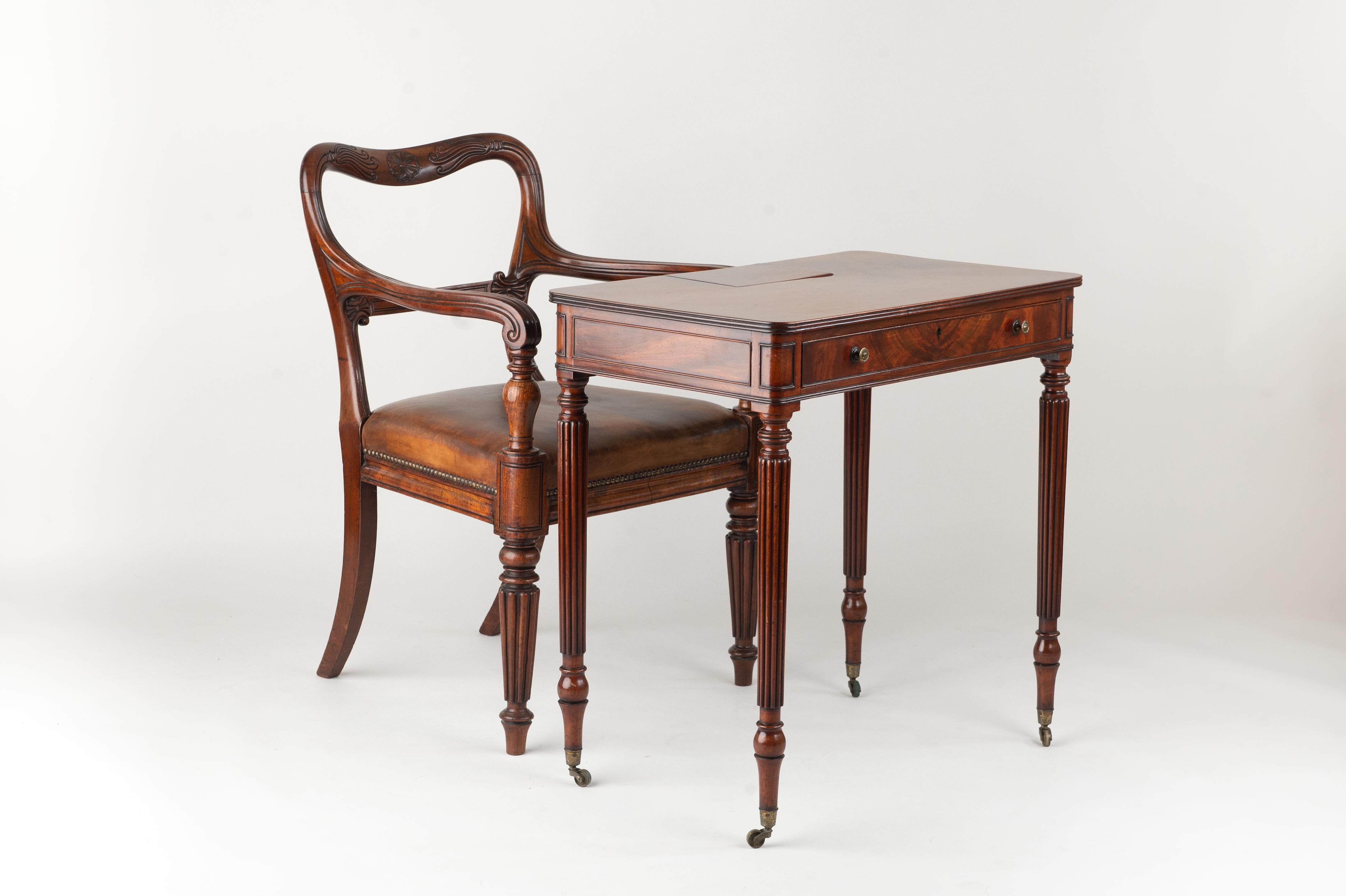 A superb George III lady's mahogany writing desk with hidden ink pots and a drawer, circa 1790. The desk stands on four reeded legs and on original brass castors. An unusual feature is a hidden store for two ink pots and a pen holder. There is a