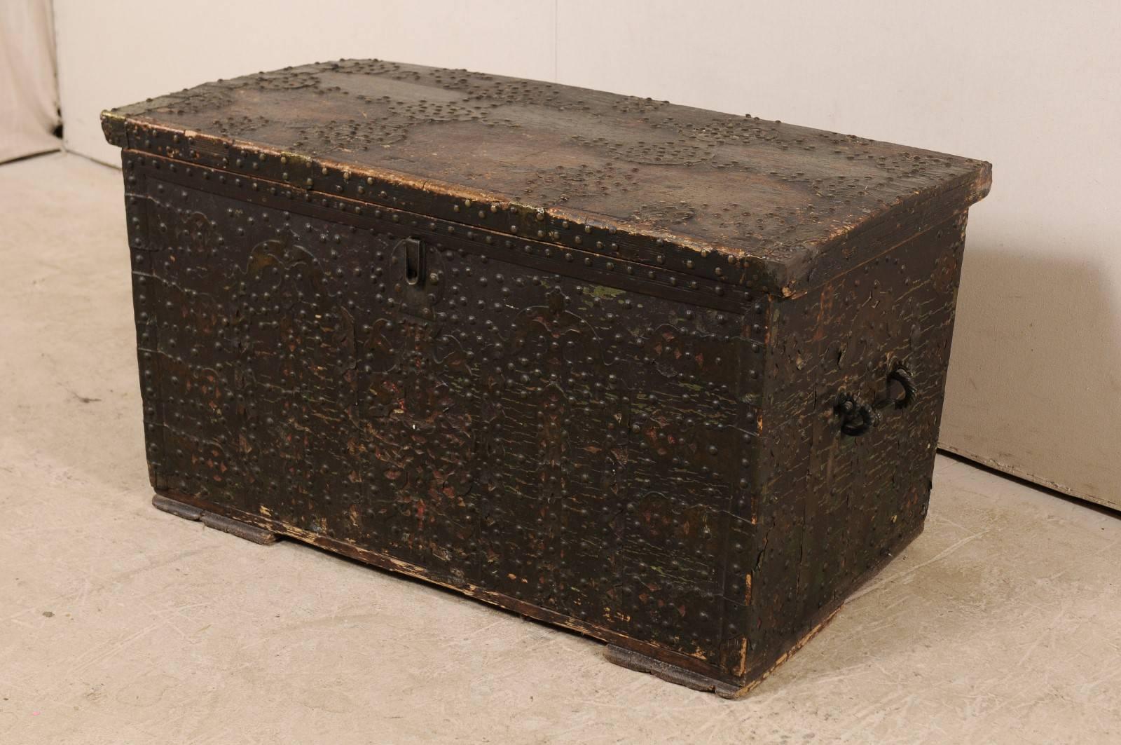 A Spanish Baroque studded coffer from the turn of the 18th and 19th centuries. This antique Spanish coffer, with it's rectangular-shaped body, has been ornately decorated with nailhead brass studs (which have a dark patina from age) along the entire