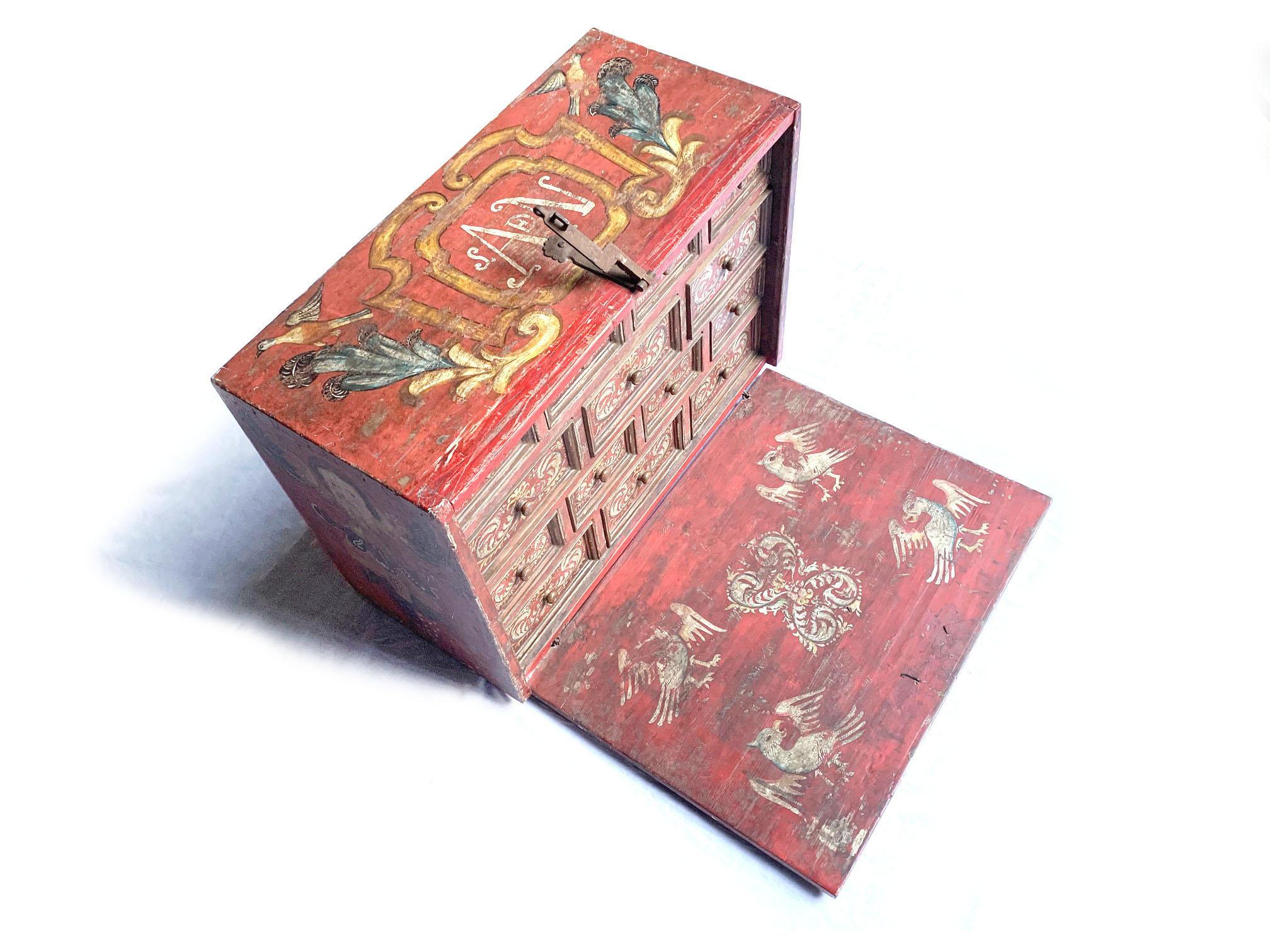 This late 18th-century Peruvian bargueño is an outstanding example of Spanish Colonial craftsmanship, featuring vibrant hand-painted decoration and intricate hardware. The front panel is adorned with a pastoral scene, depicting a man and woman in an