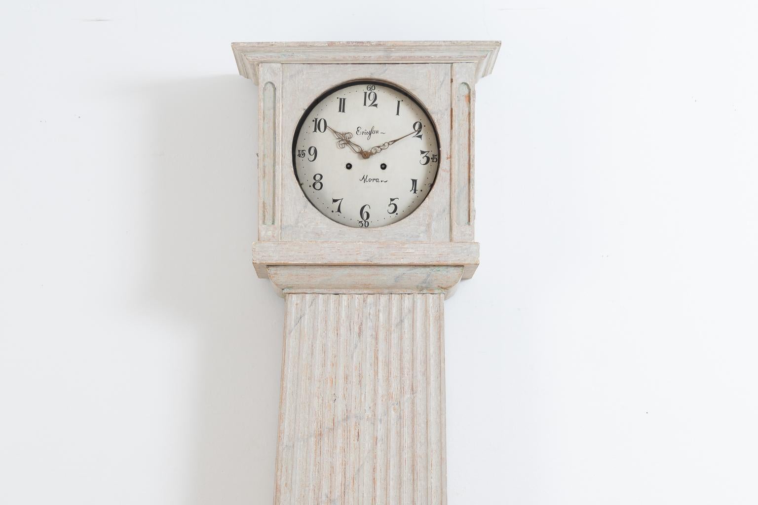 Swedish long case clock from the Gustavian period. The clock is unusual because of its straight model. Decorated with a ribbed decor that stretches the majority of the case, spanning from just under the head down to the foot on three sides. The